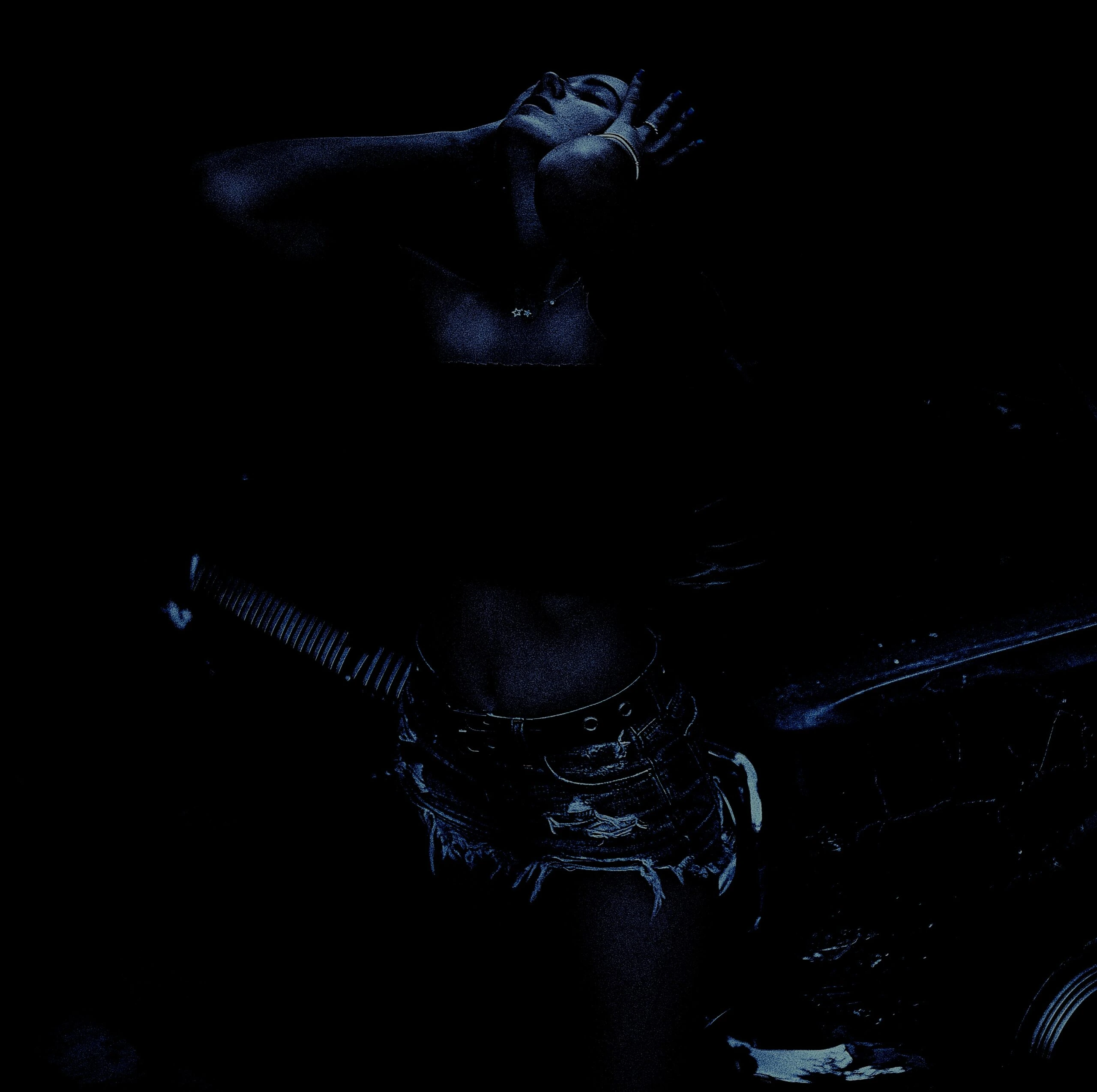 A dramatic pose captured in high contrast, featuring a person in torn denim shorts, exuding a rebellious metalhead spirit.