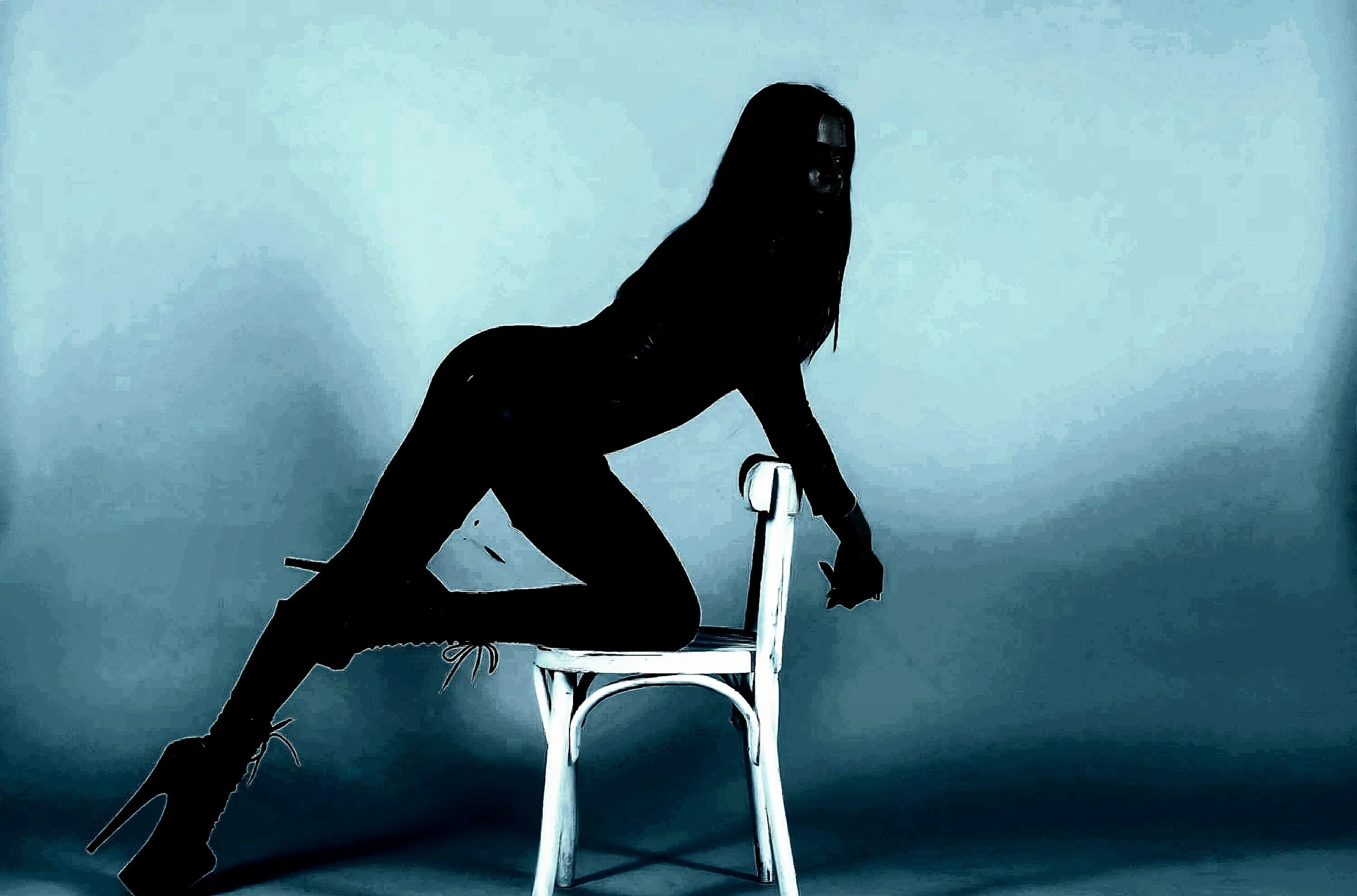Silhouette of a woman in a provocative pose on a chair, creating a sense of mystery and allure.