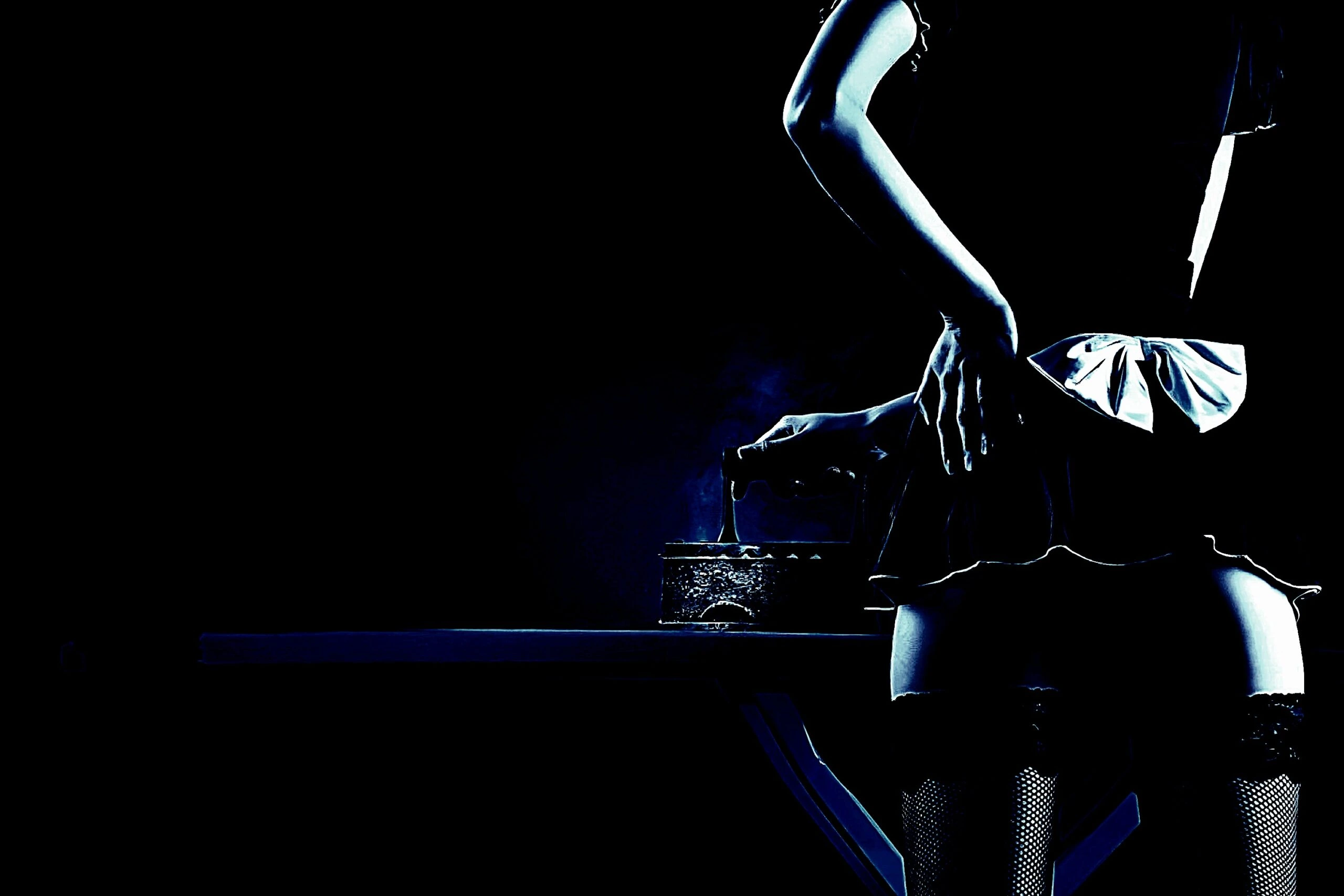 A gothic scene with a woman in a short skirt and fishnet stockings standing by a dimly lit bar.