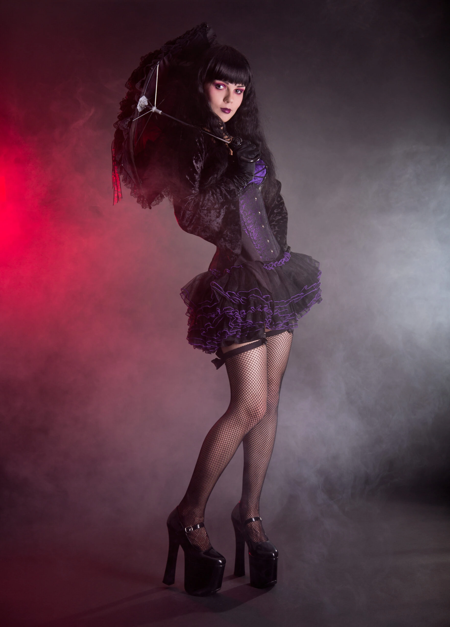 Gothic elegance portrayed by a model holding a lacy black parasol, wearing a velvet corset dress with purple highlights.