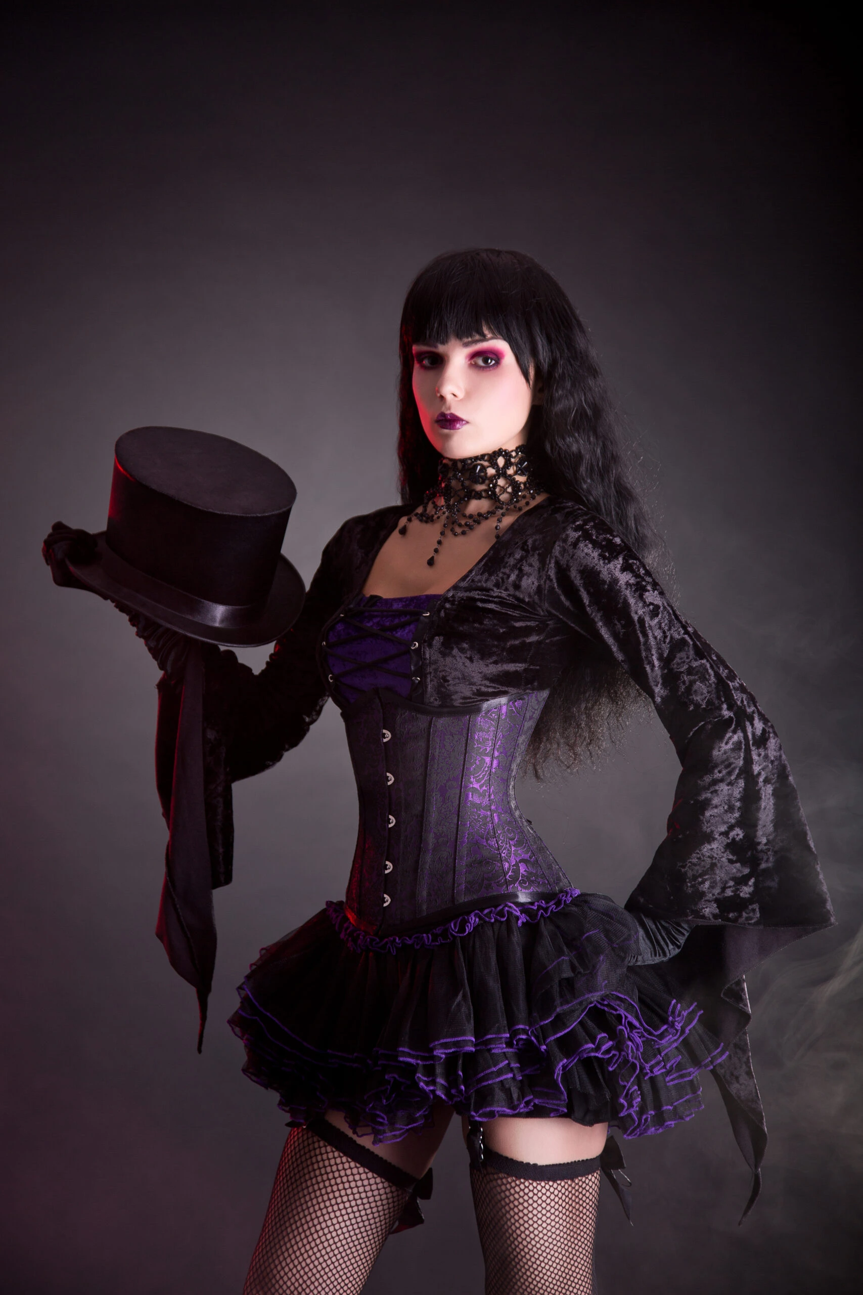 The same goth woman now holding a top hat, with a subtle change in her expression, enhancing her dramatic dark makeup and the detailed choker around her neck.