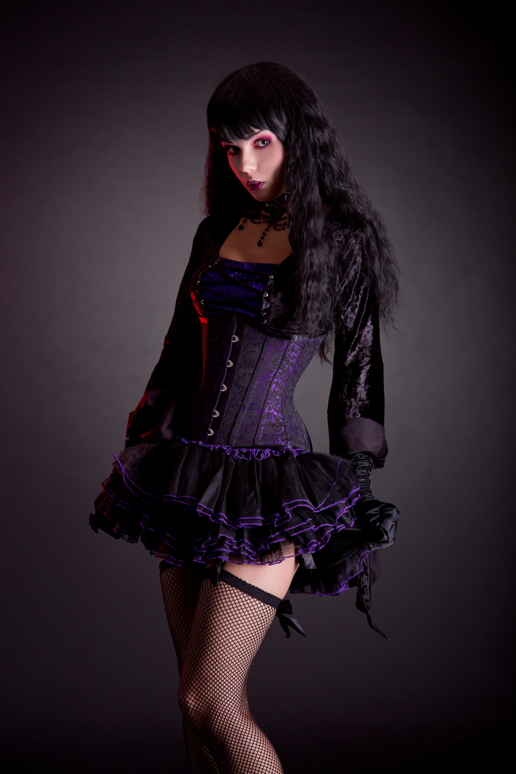 Full-length view of a gothic-inspired outfit featuring a velvet corset dress with sumptuous purple and black layers.