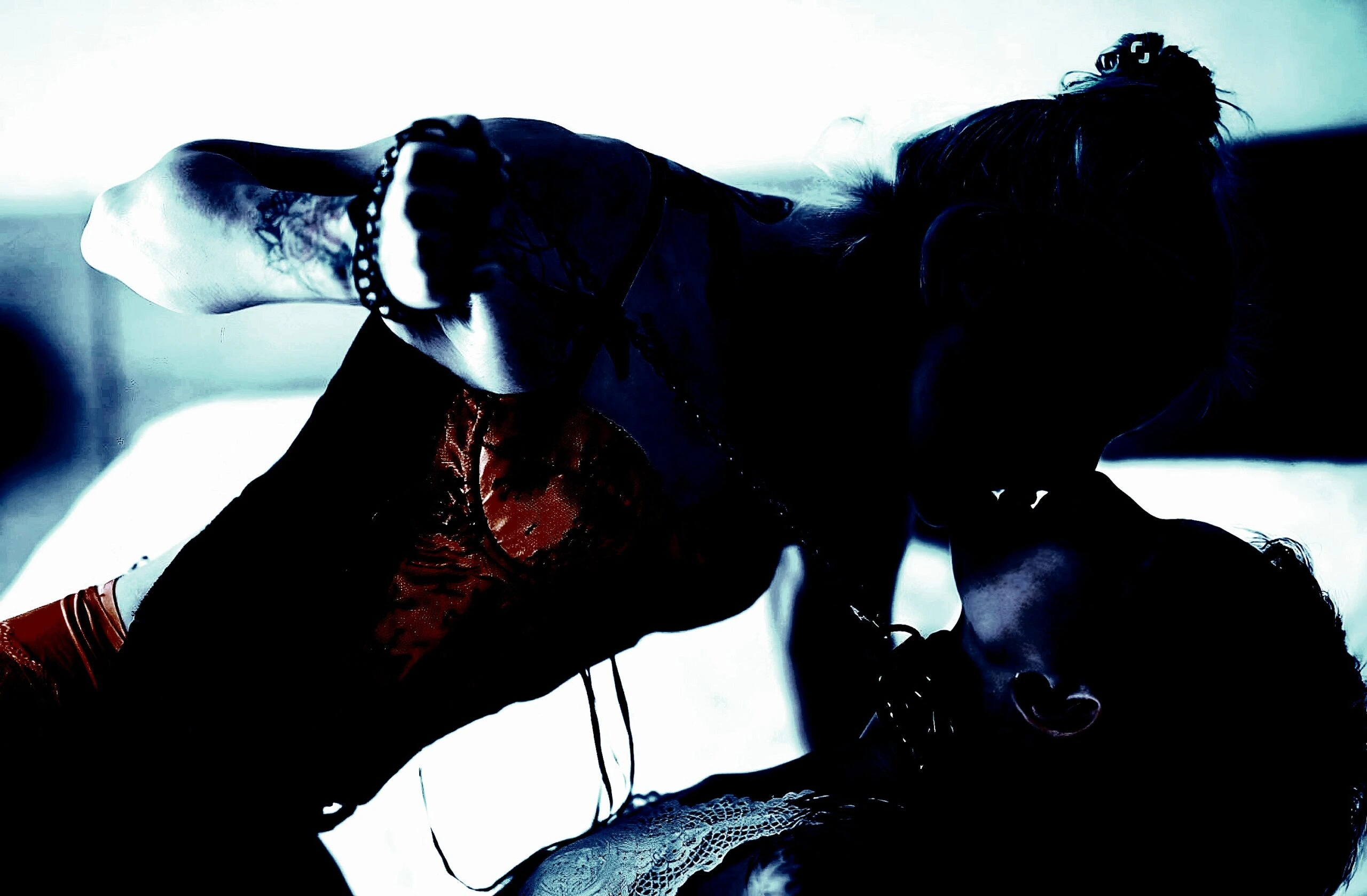 An intense scene showing two women engaging in a passionate embrace, with a dark and moody backdrop.