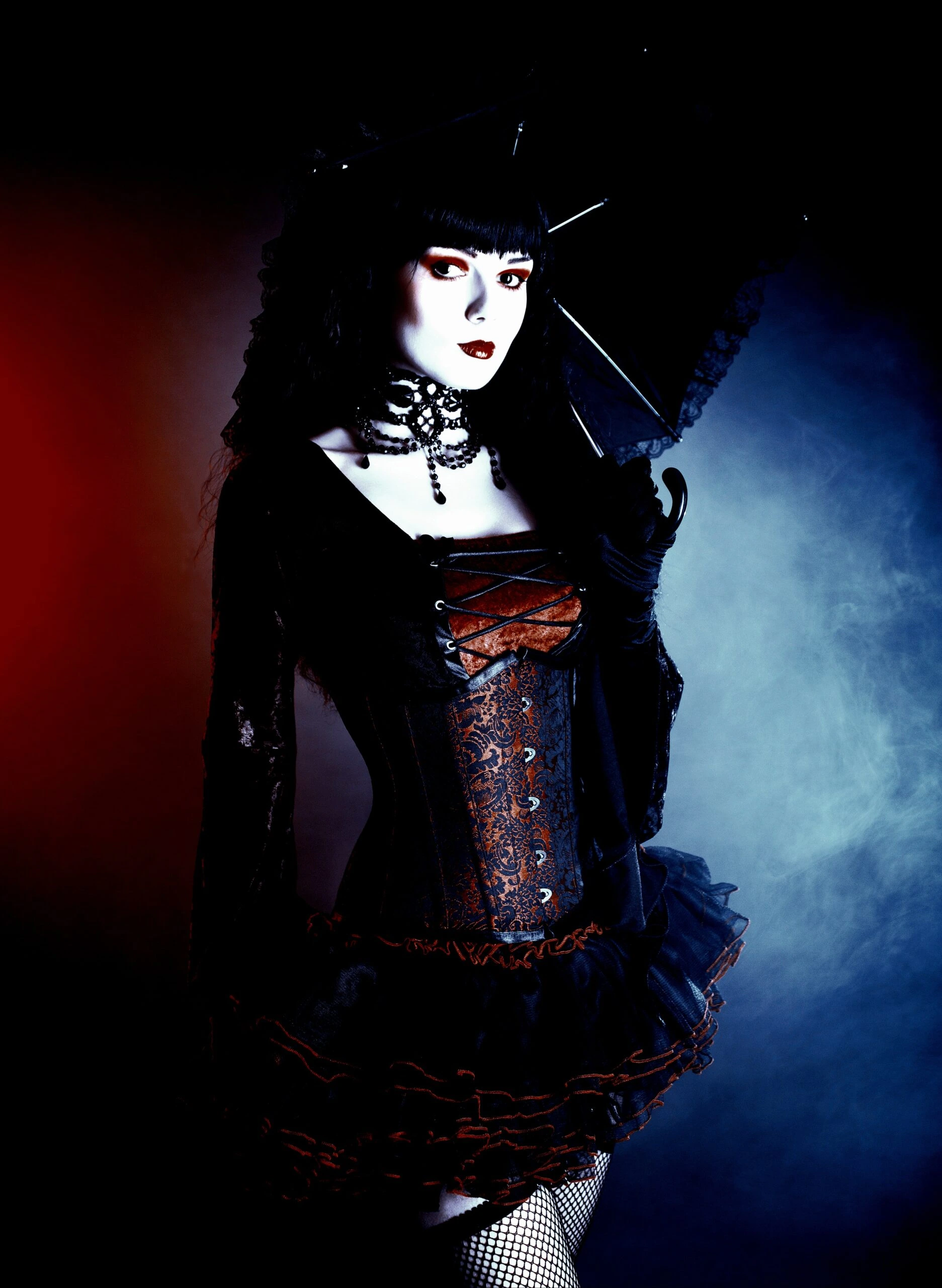 Dramatic gothic fashion portrait featuring a woman in a corset and layered skirt, with intense eye makeup.