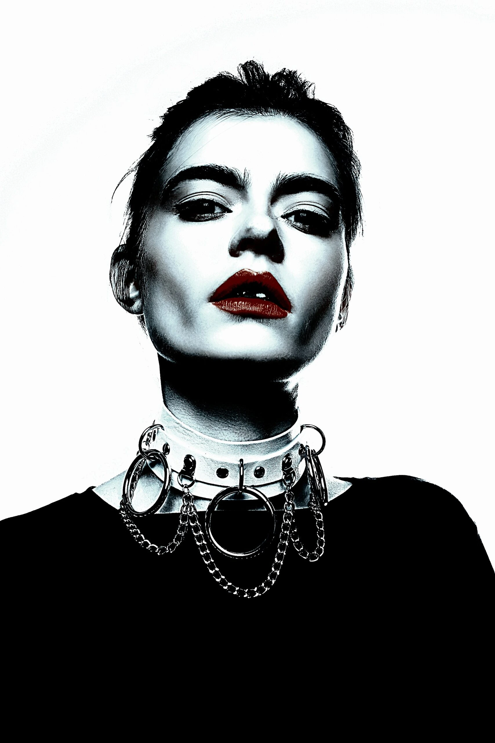 Portrait of a woman with bold Gothic jewelry featuring a multi-ring chain necklace.