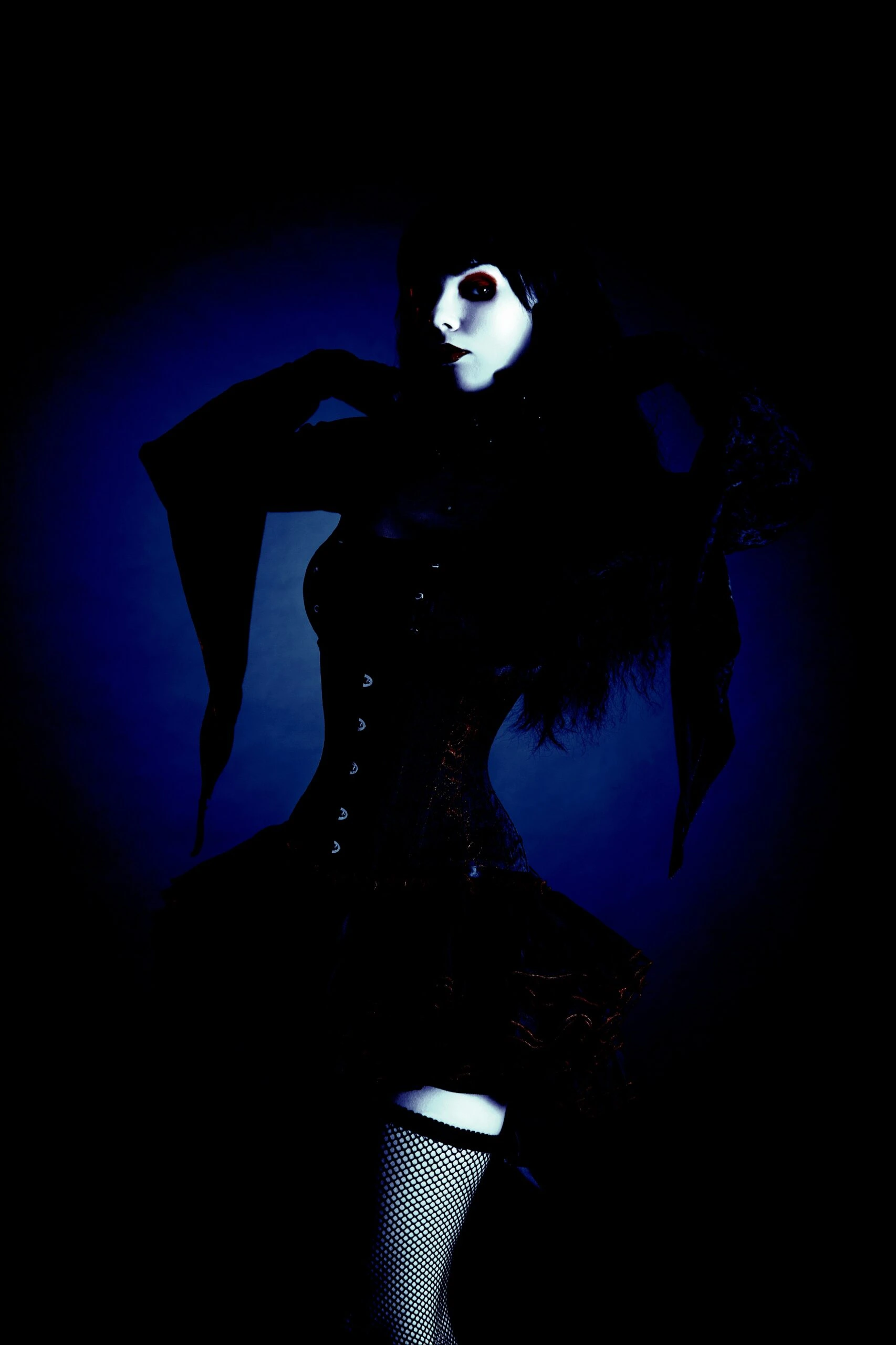 Gothic woman posing dramatically with arms raised in the Ultimate Gothic Ensemble.
