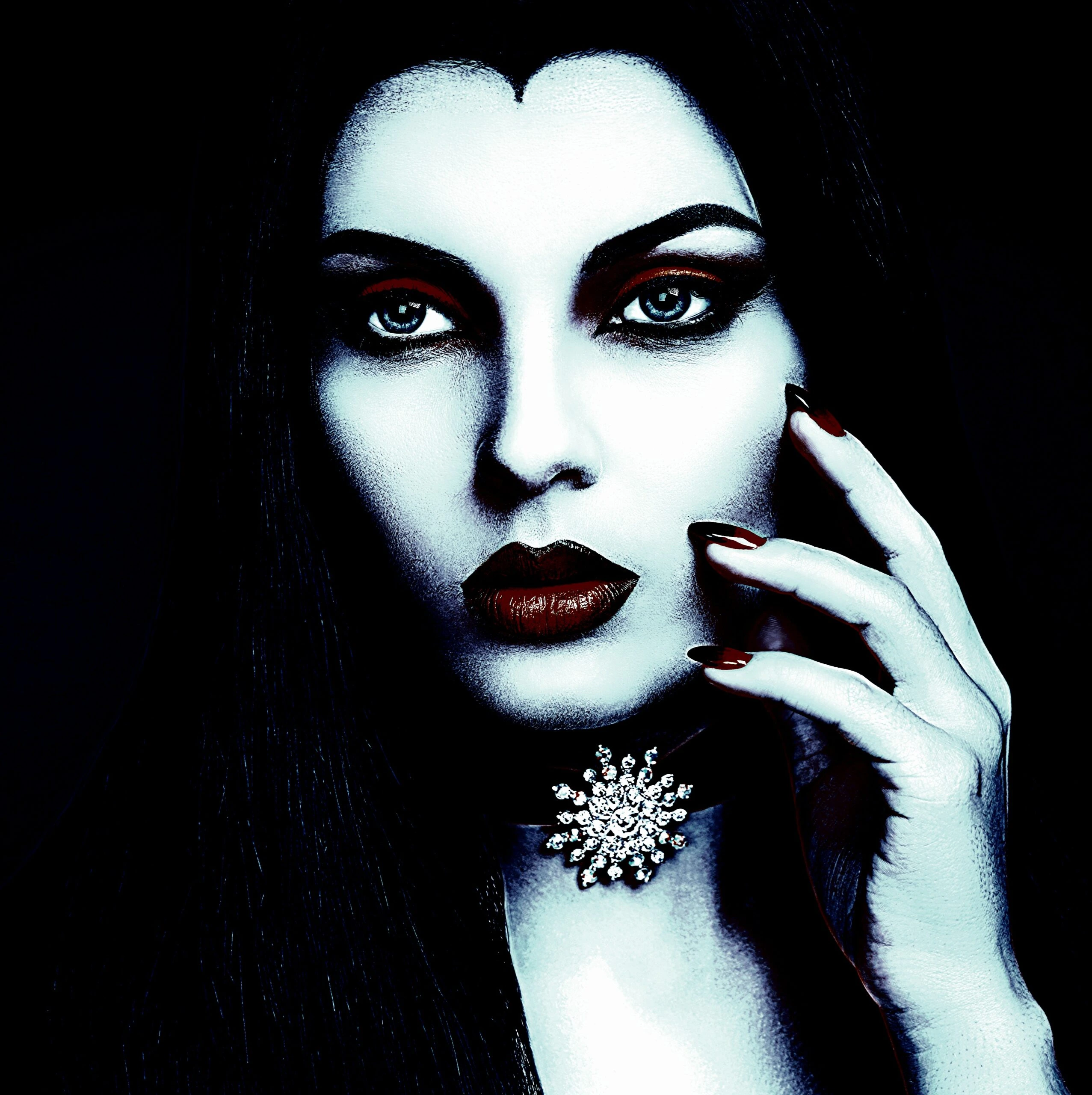 Gothic jewelry in a dark setting with a woman wearing an ornate necklace and lace gloves.