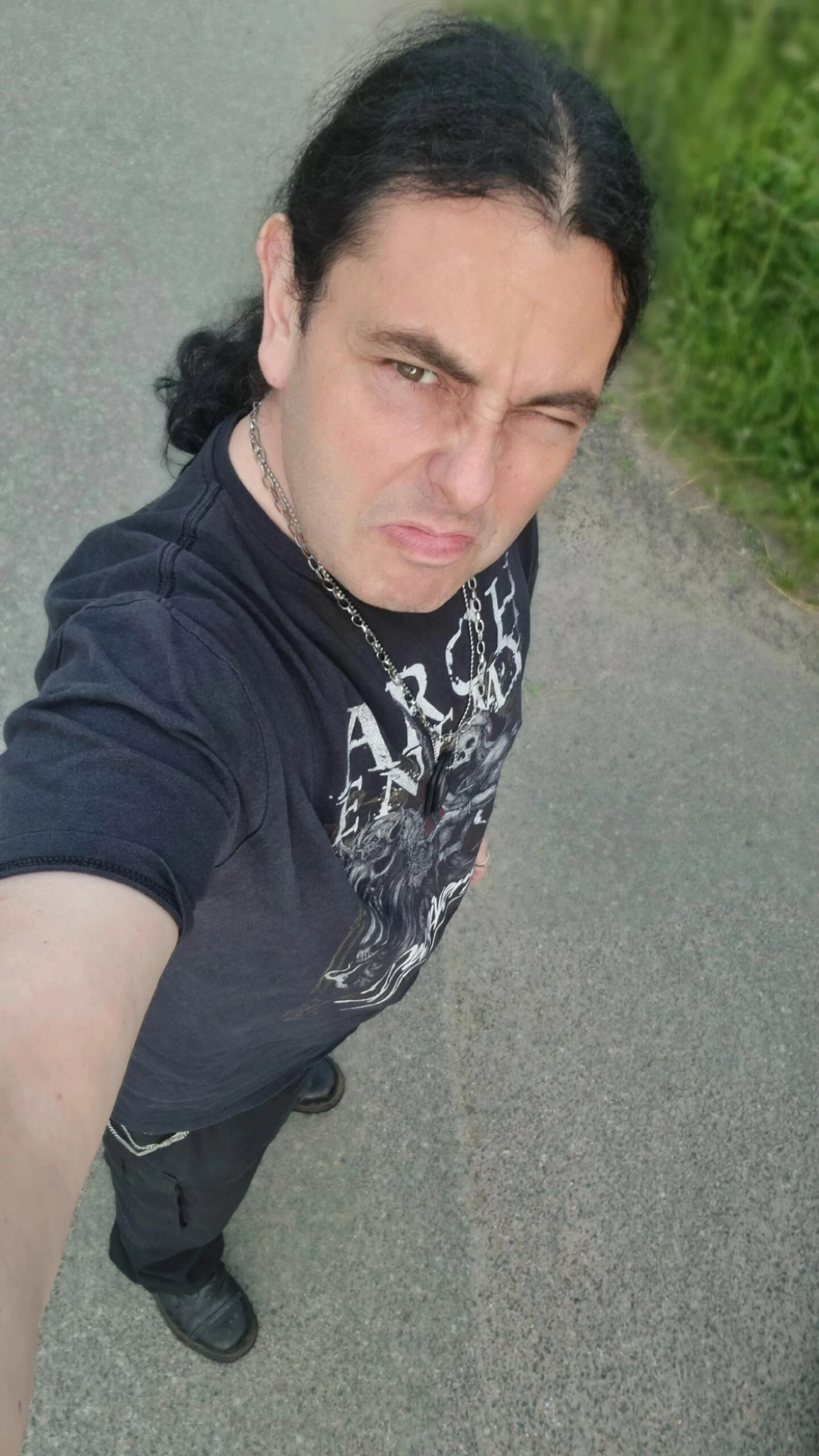 Man wearing an Arch Enemy shirt winking while taking a selfie at Sweden Rock Festival 2024