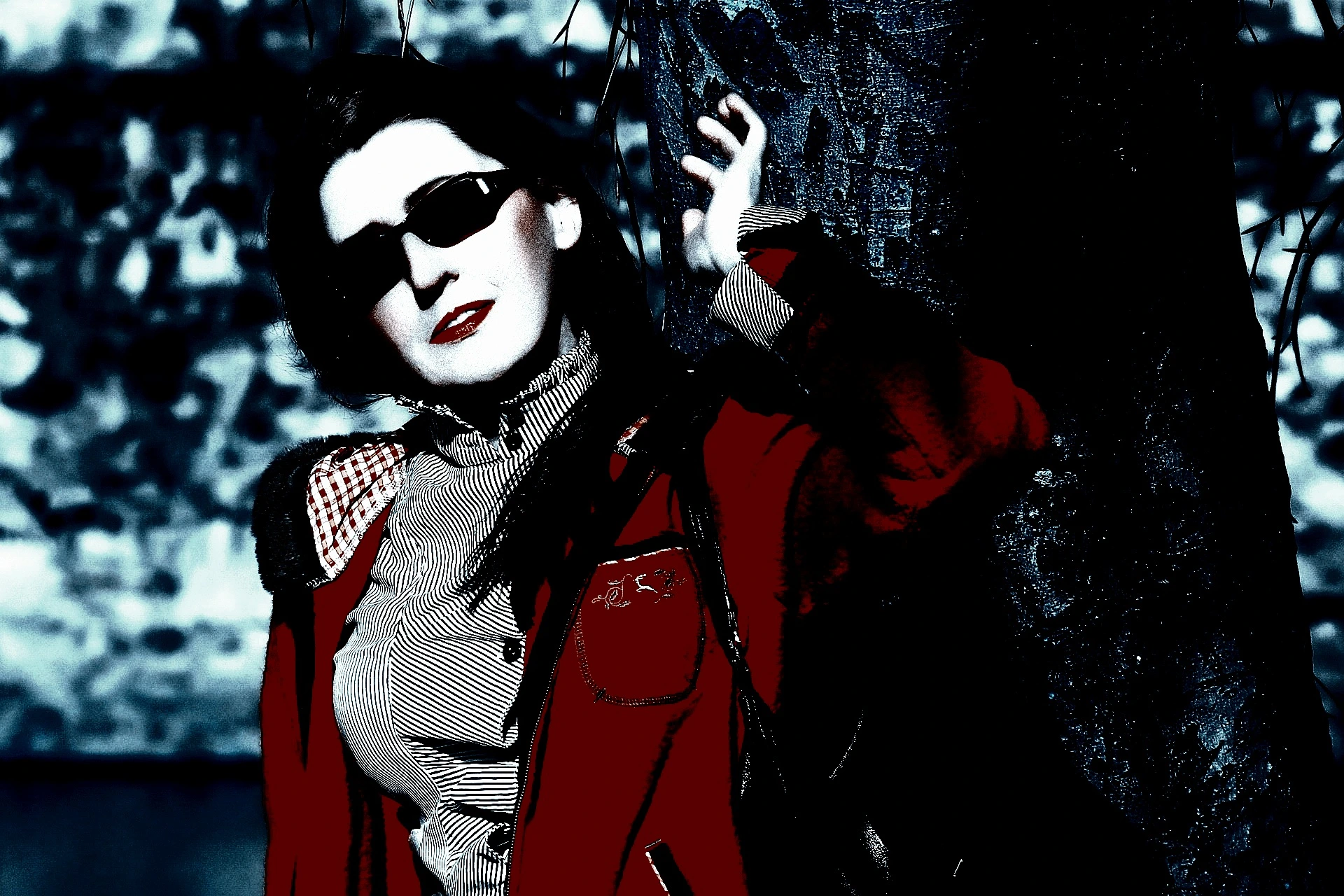 Edgy woman in sunglasses and a unique outfit, standing in front of a retro vehicle with a playful expression.