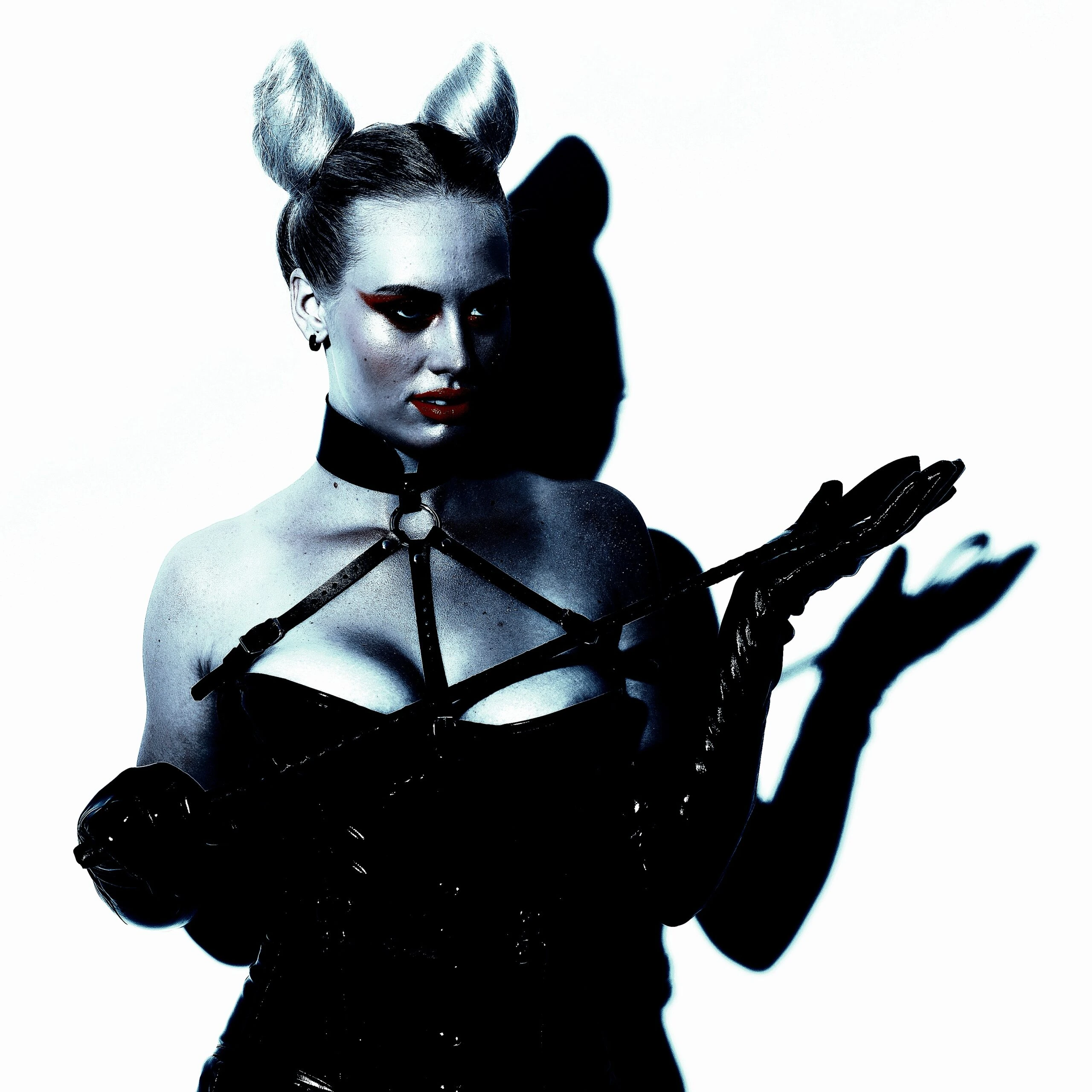 A woman holding a whip in BDSM attire, illustrating the exploration of pain thresholds and emotional catharsis in BDSM.