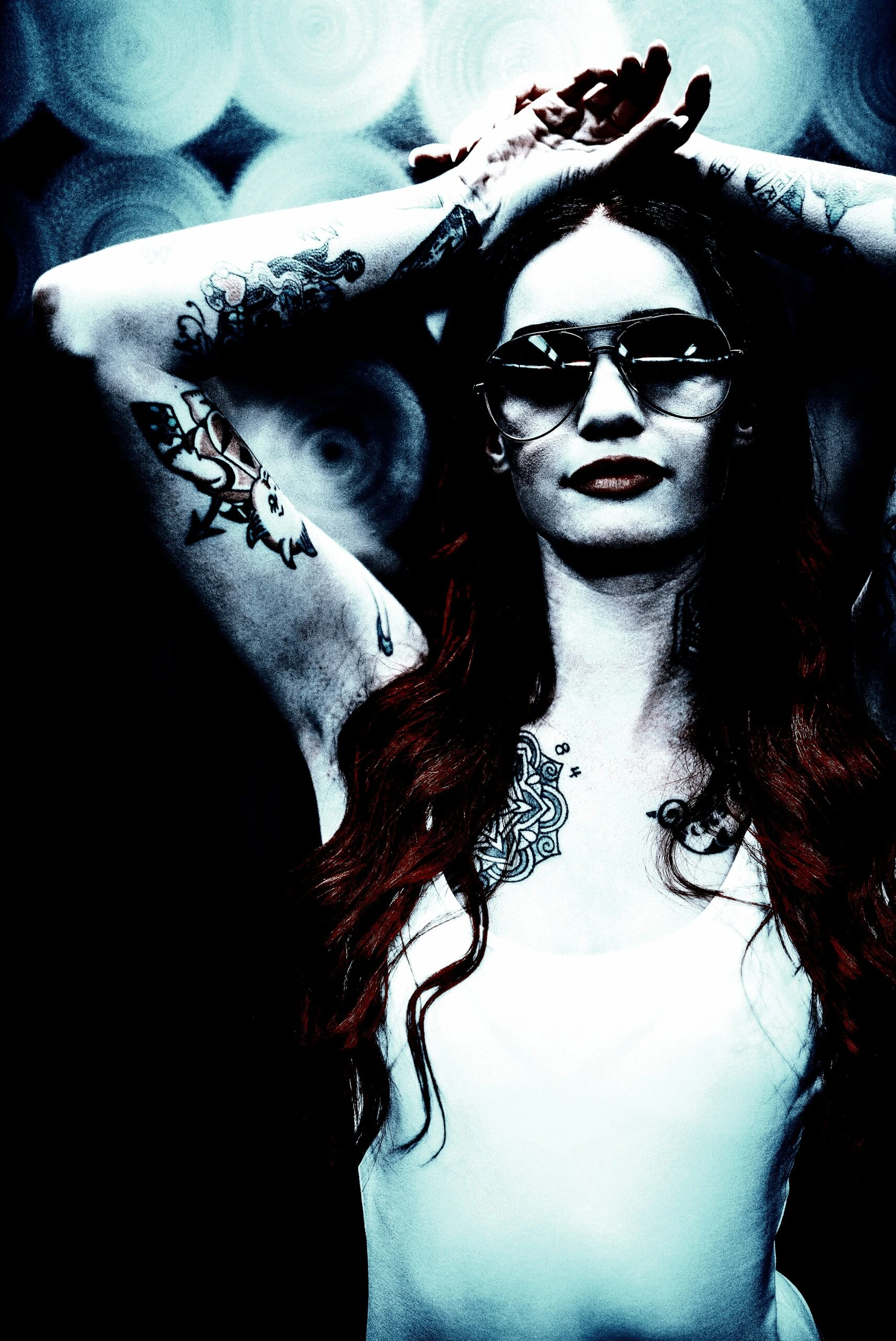 Tattooed individual with sunglasses, representing modern BDSM sexual activities and style.