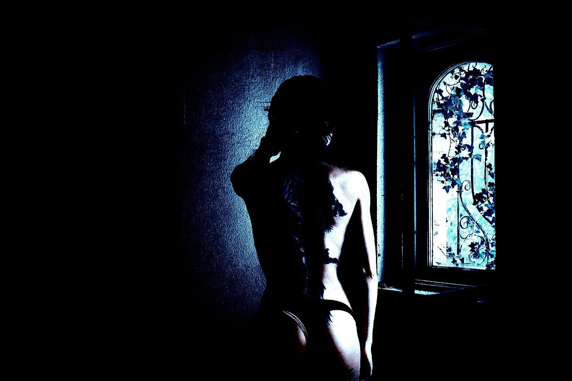 Person posing against a dark background, exemplifying the allure of BDSM sexual activities.