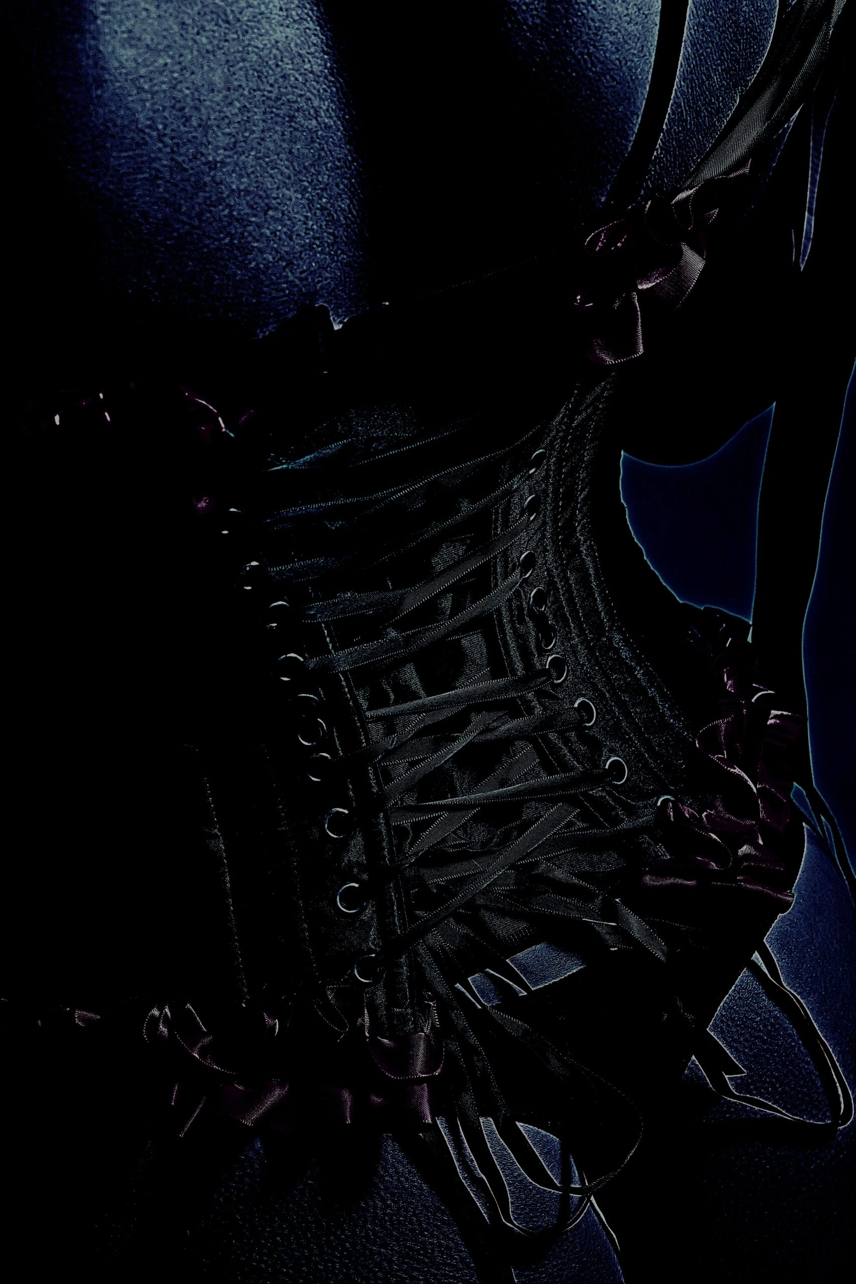 Close-up of a black corset with intricate lacing and dark, gothic aesthetic.