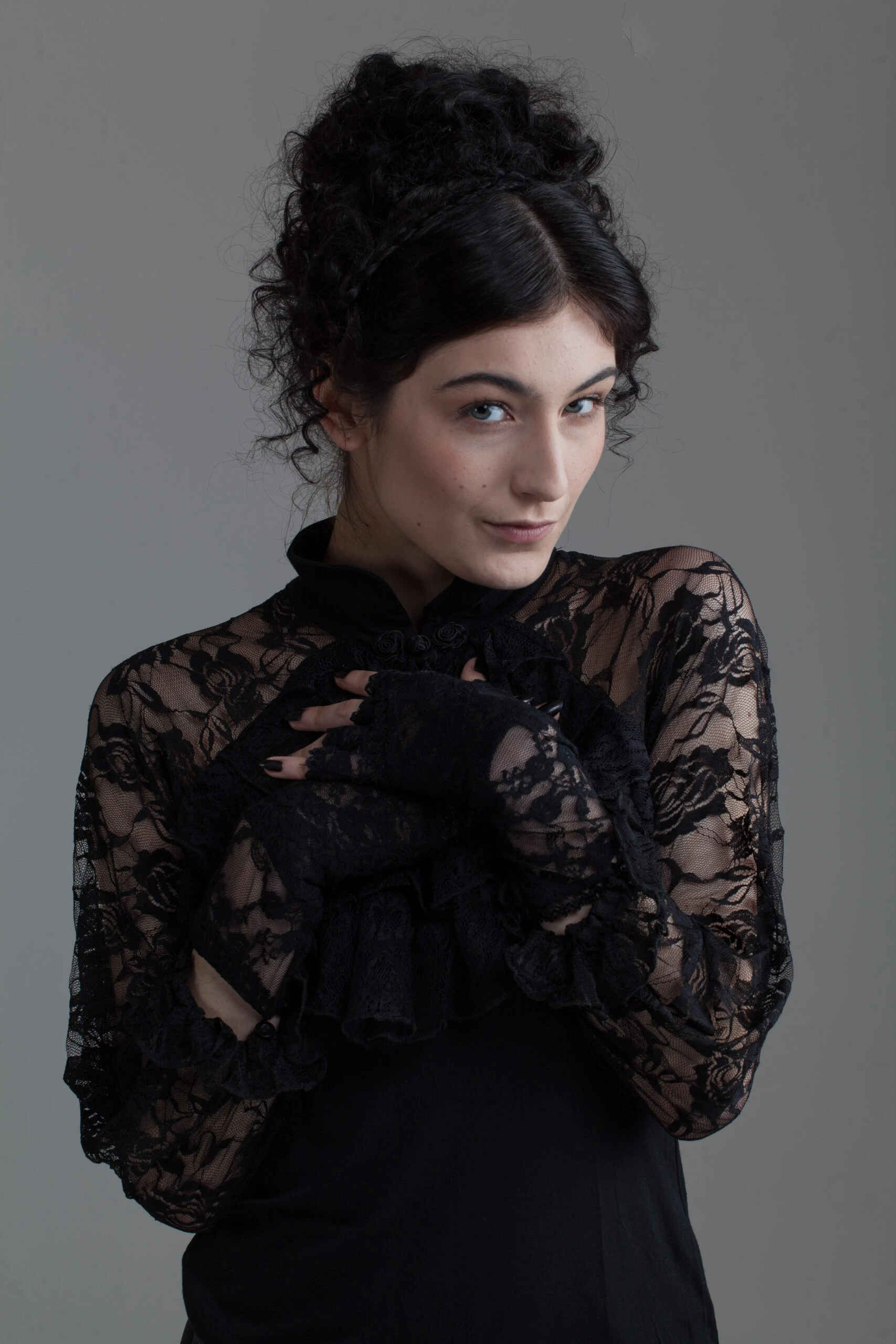 Woman in a Victorian-style Gothic lace blouse, posing with a mysterious smile.