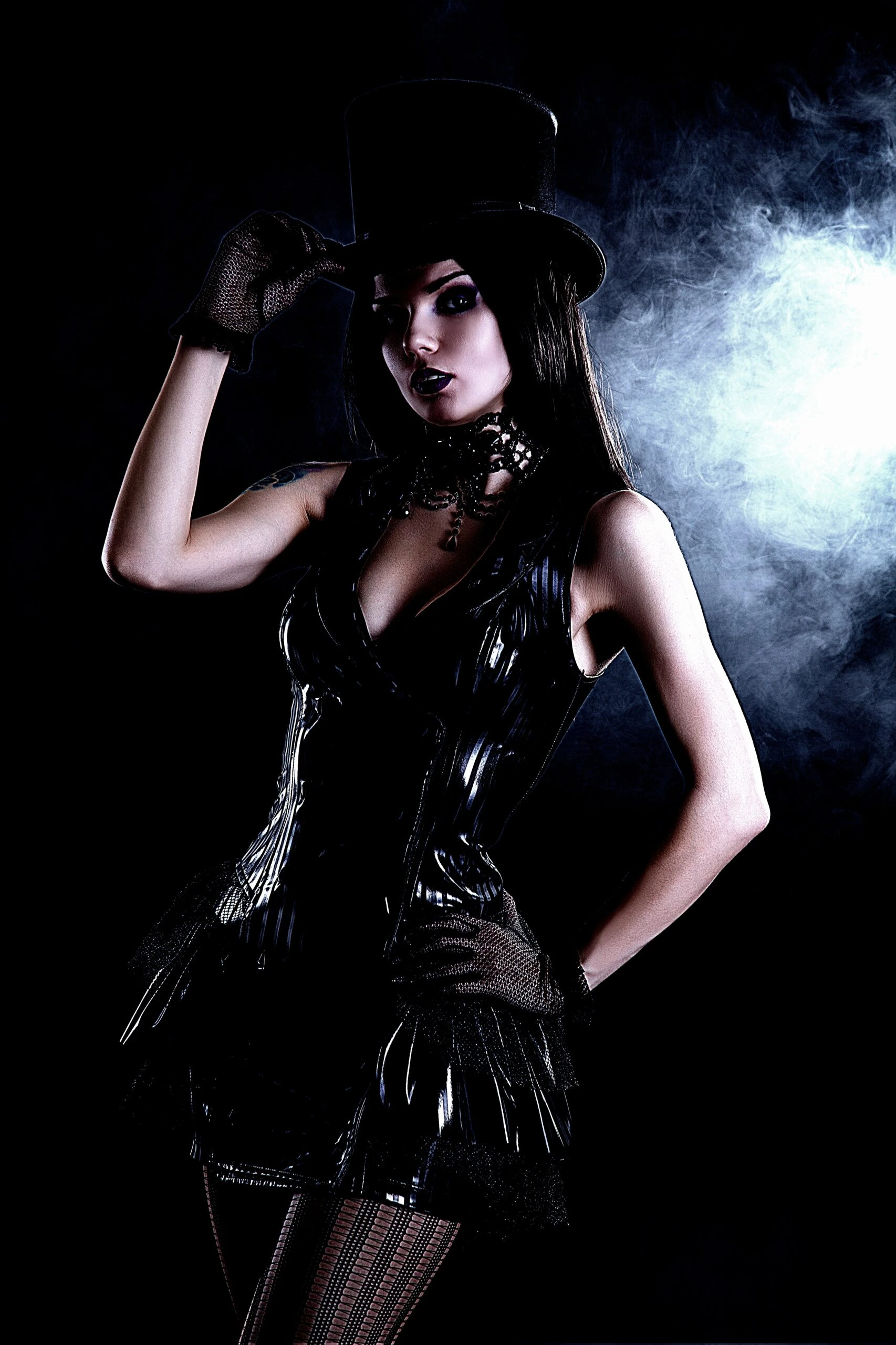 Embracing Gothic Elegance: Woman in a black corset and top hat, posing with a mysterious expression in a dark, smoky setting.