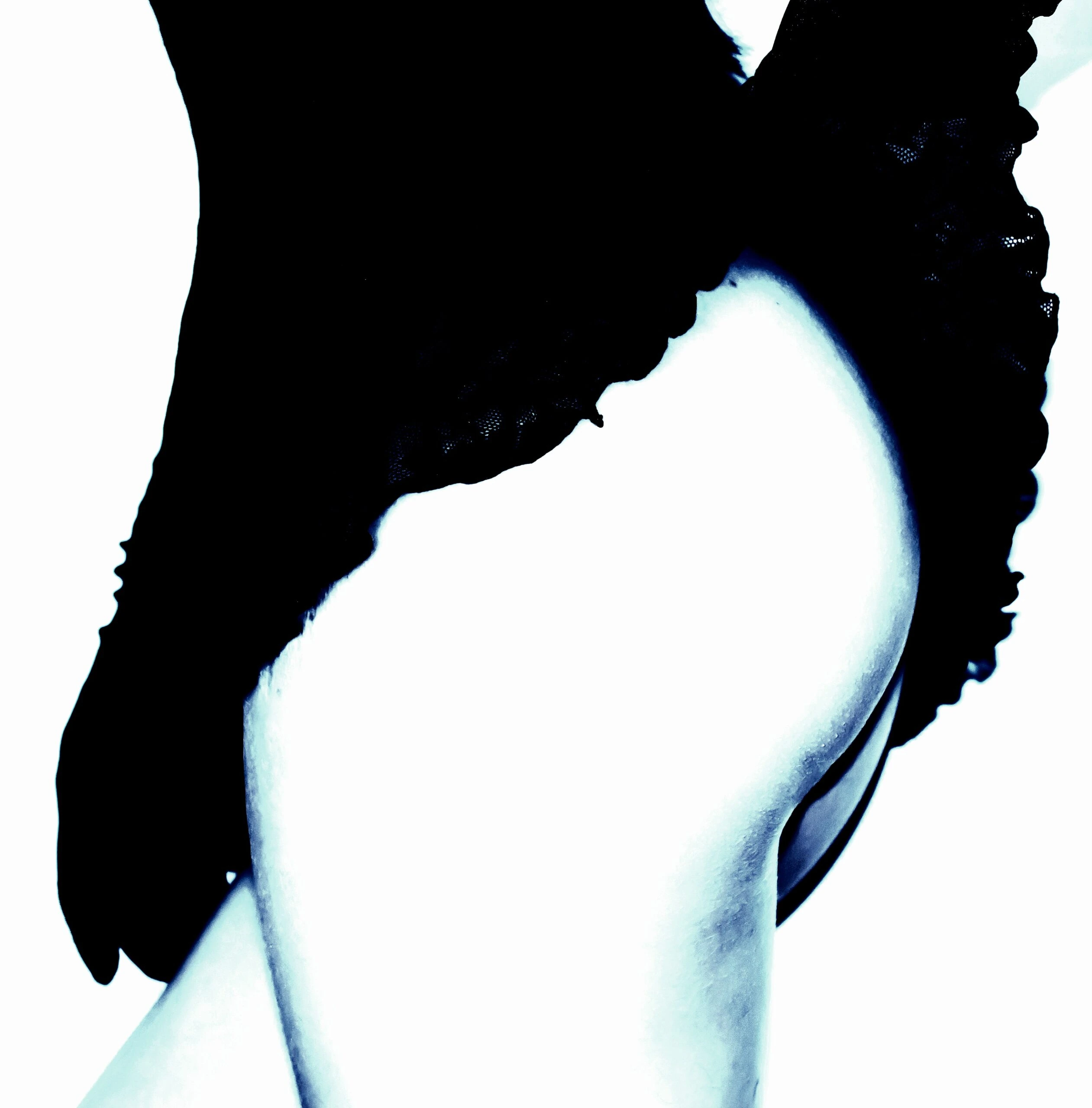 Close-up of a woman's toned and curvy body in a dark setting, wearing black lingerie.