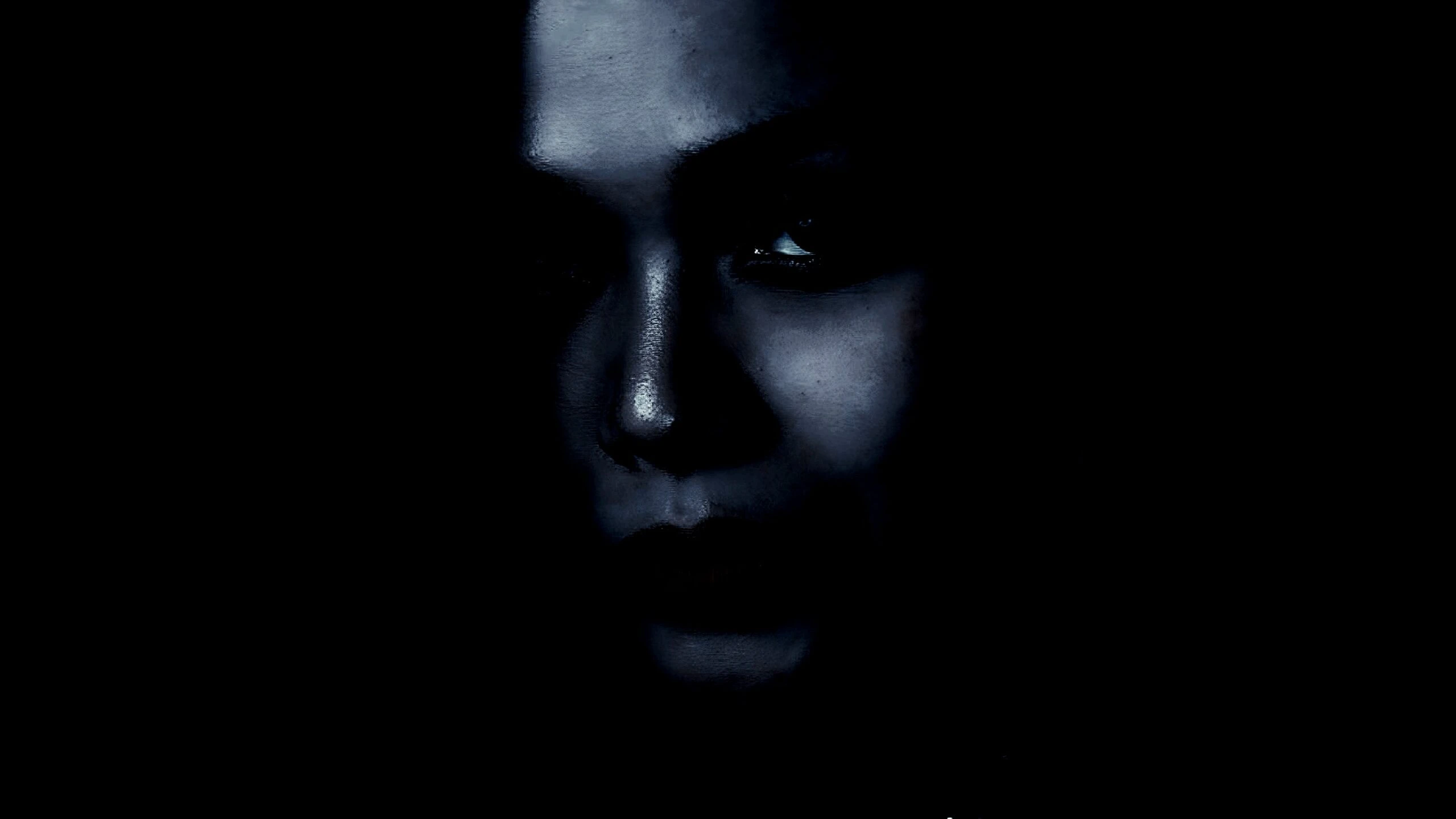 Mysterious face of a woman partially visible in the dark.