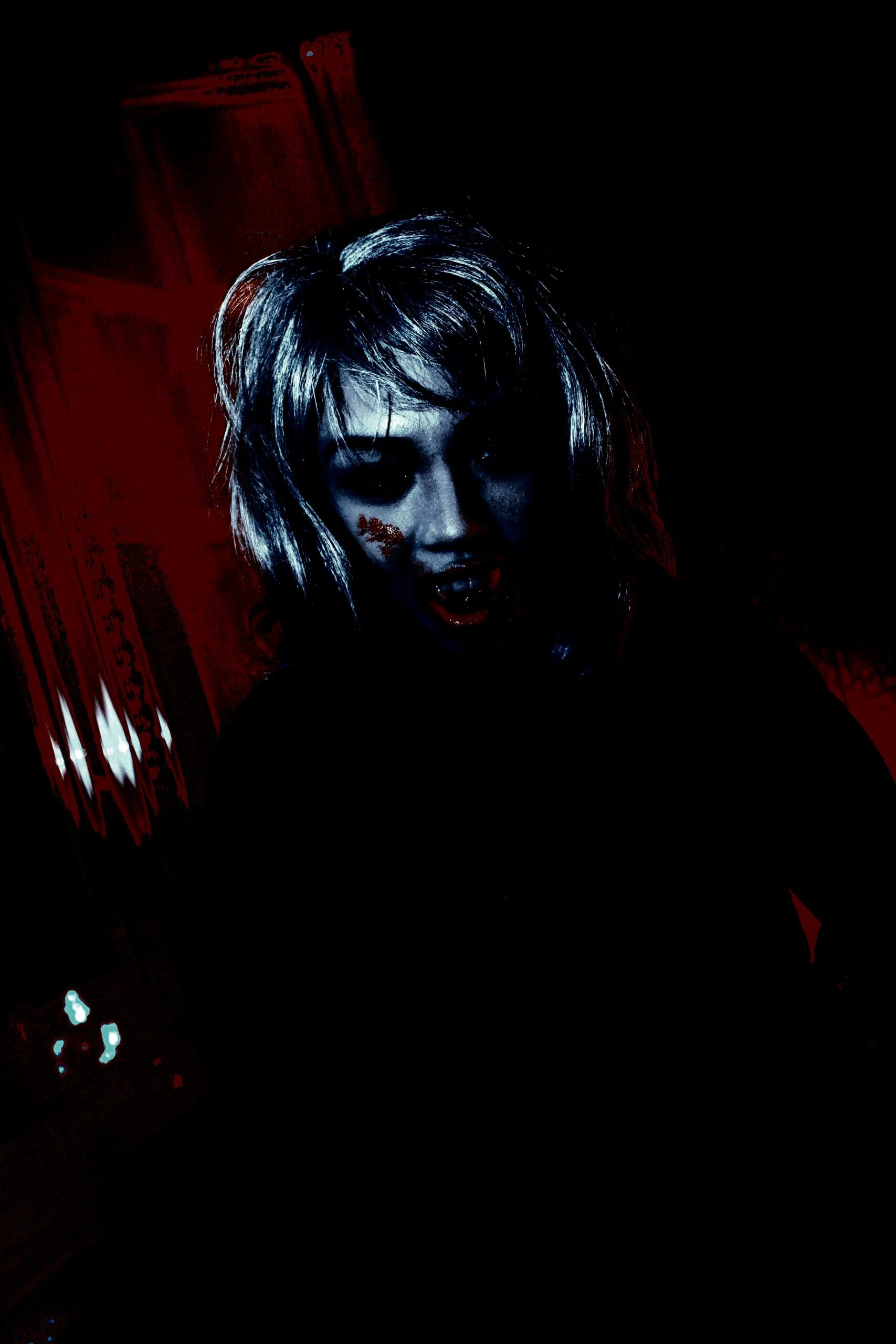 Gothic-themed cosplayer with blood effects on face, creating a sinister and haunting expression.