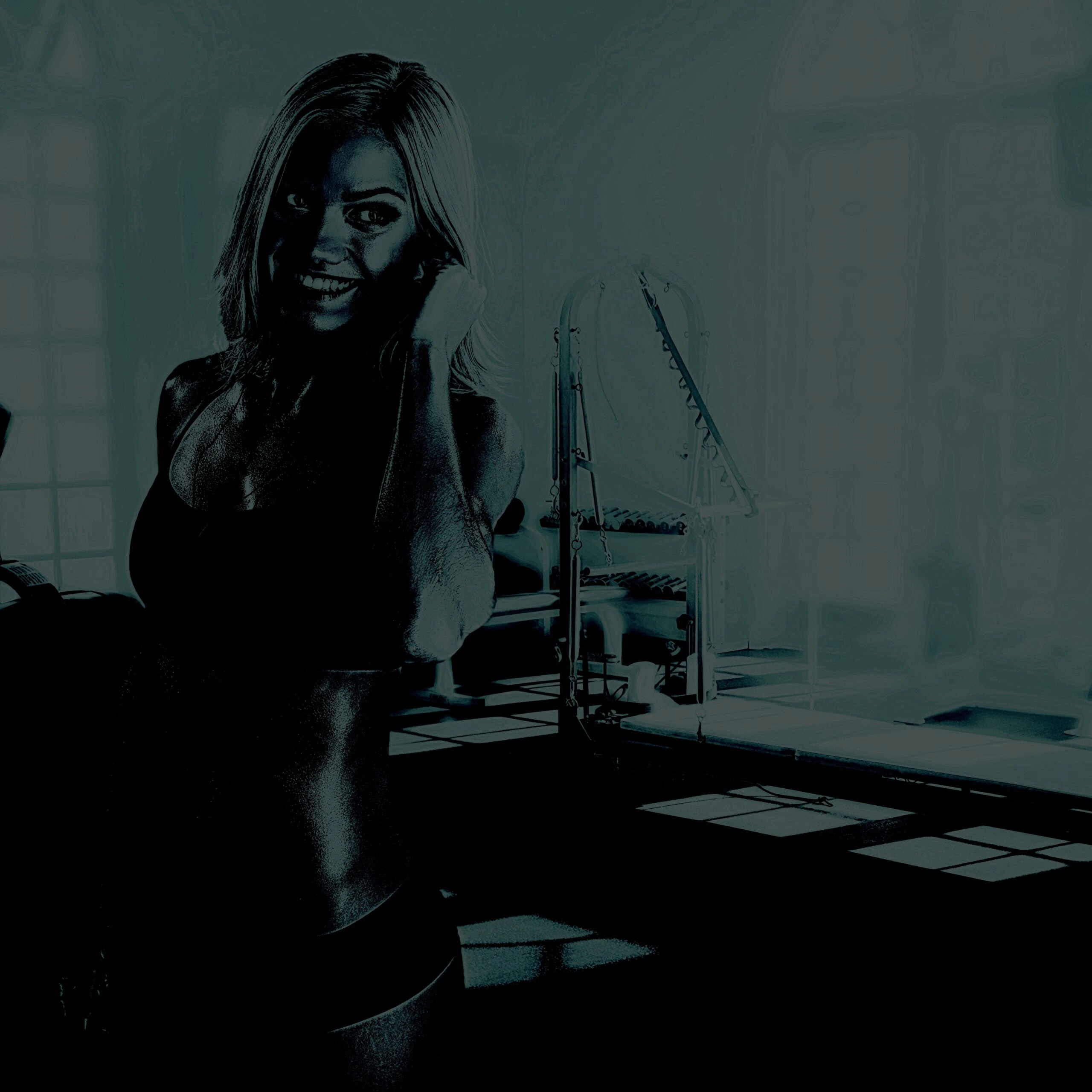 Female bodybuilder lifting a dumbbell in a dark gym with dramatic lighting
