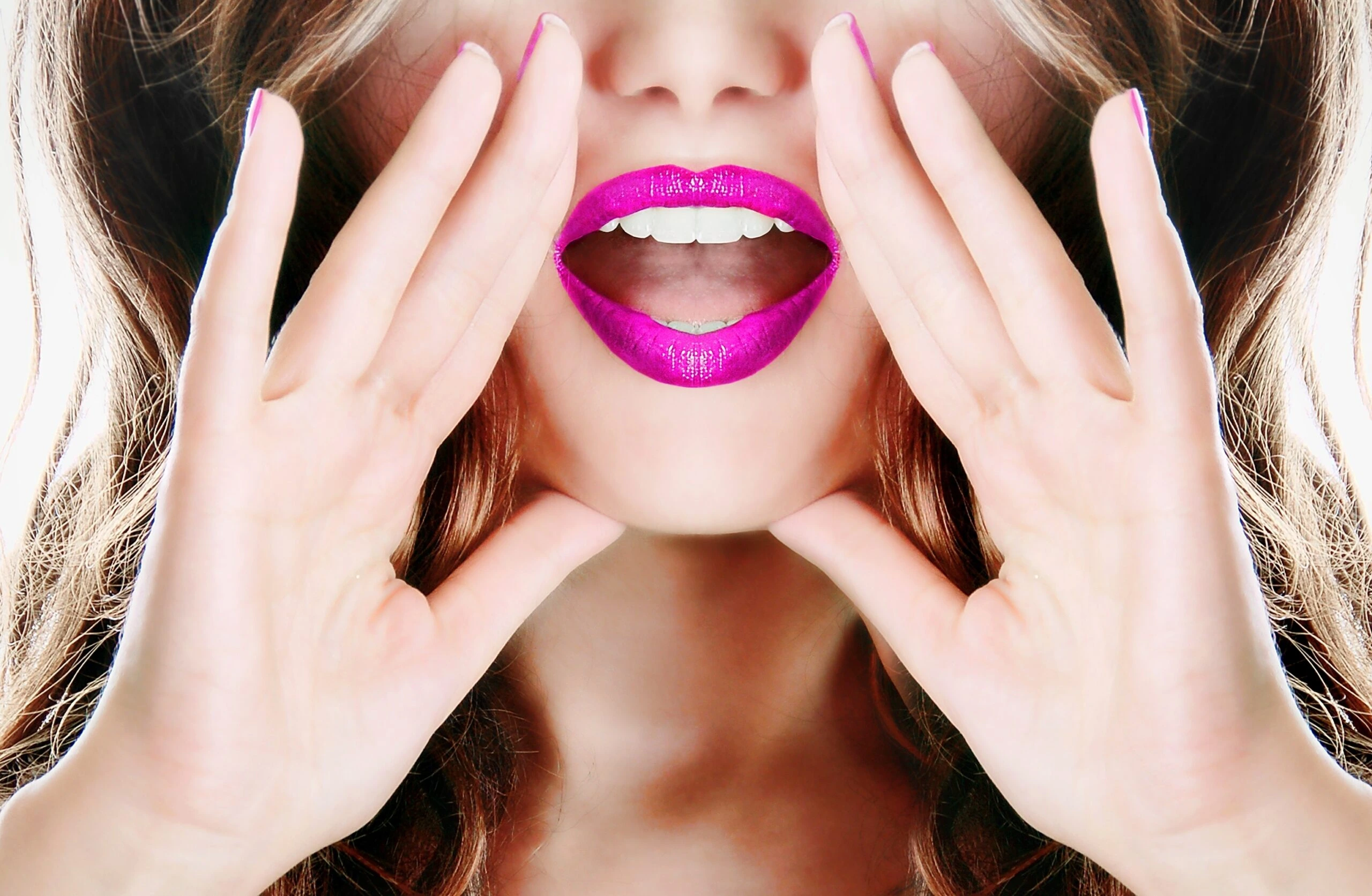 Close-up of a woman's bright pink lips, hands cupped around her mouth, shouting or calling out.