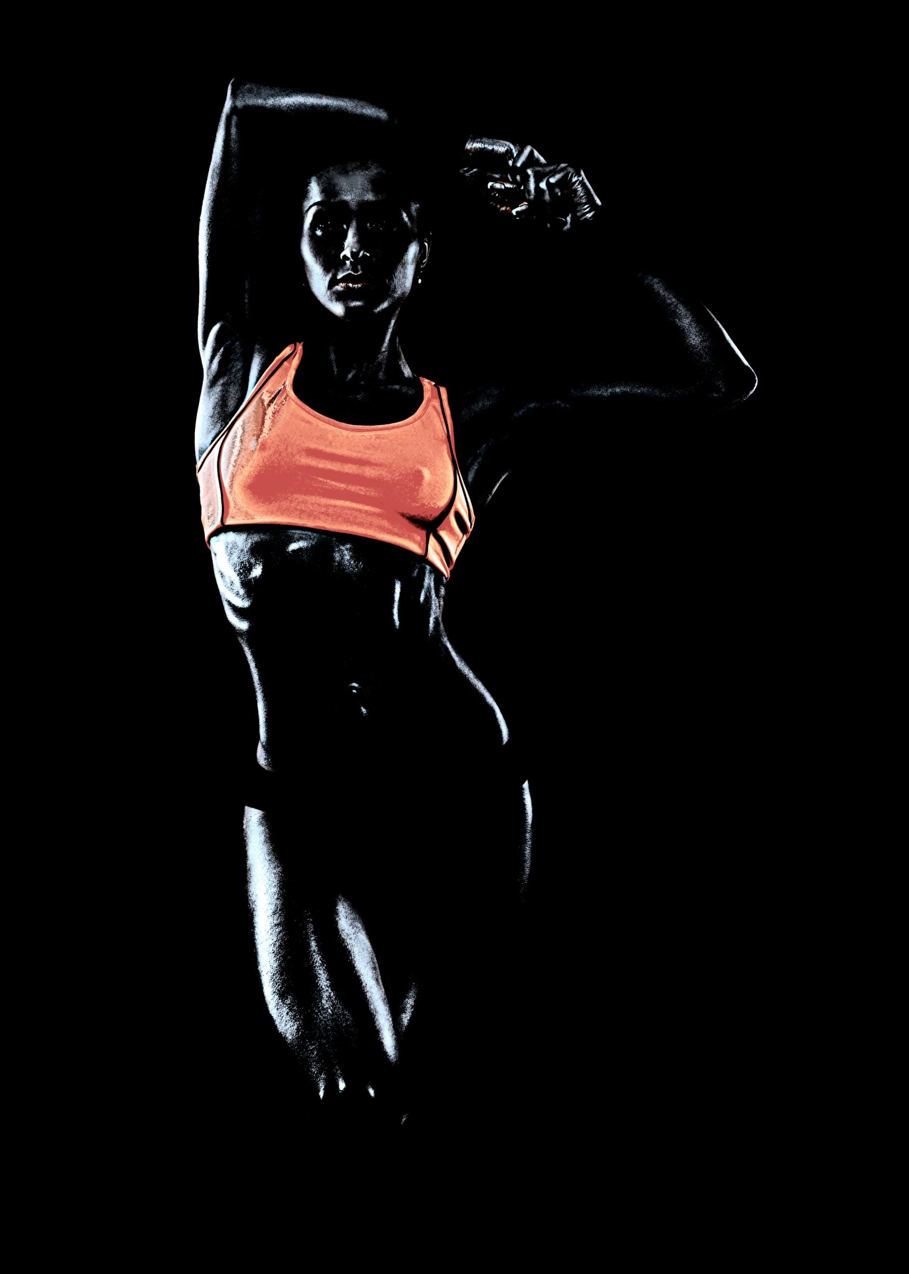 Close-up of a muscular woman's back and shoulder in a dark, moody gym setting