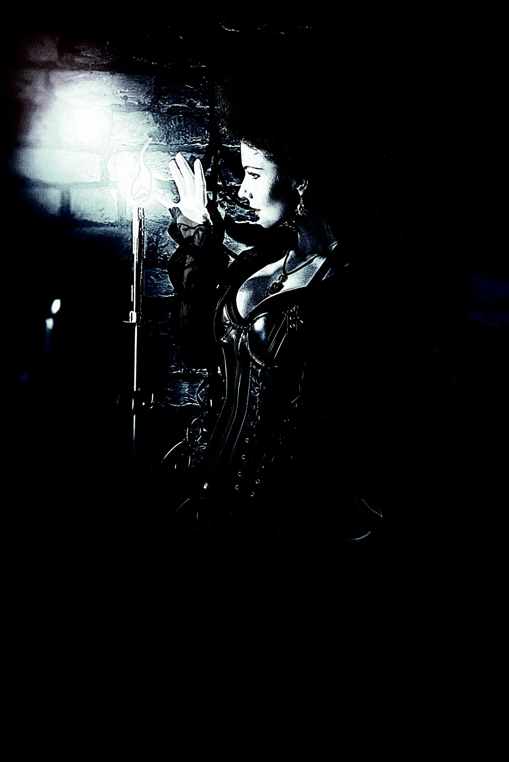 A gothic woman dressed in a corset with intricate Victorian details, illuminated by candlelight as she touches a dark, stone wall.