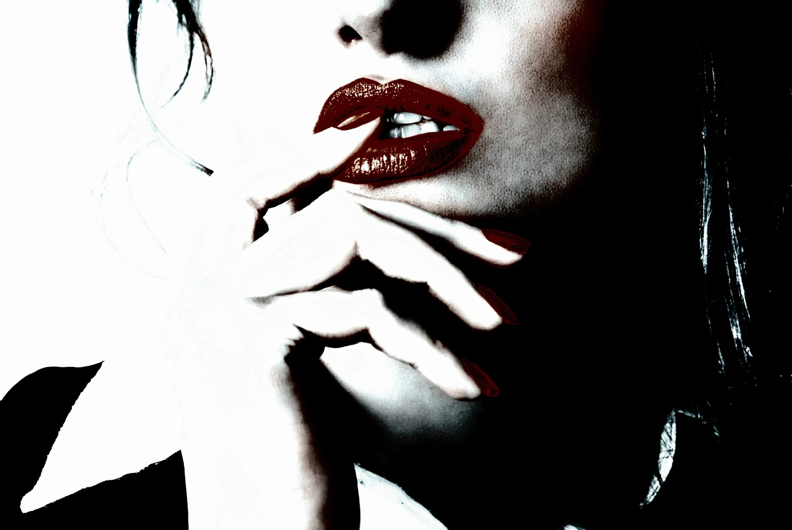 Close-up of a woman's lips and hand, with red lipstick and nail polish. 