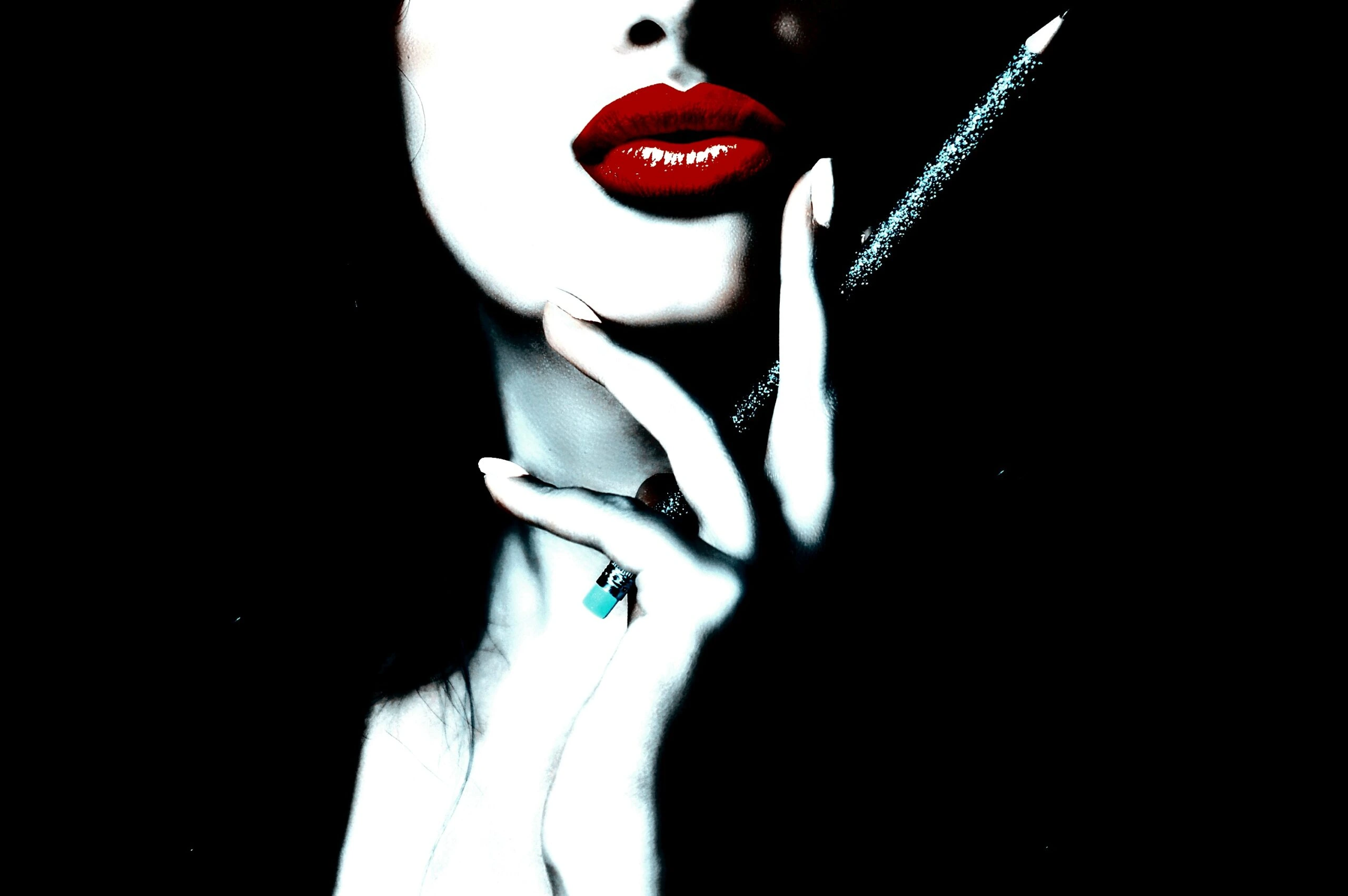 Close-up of a woman's red lips and hand with a pen.
