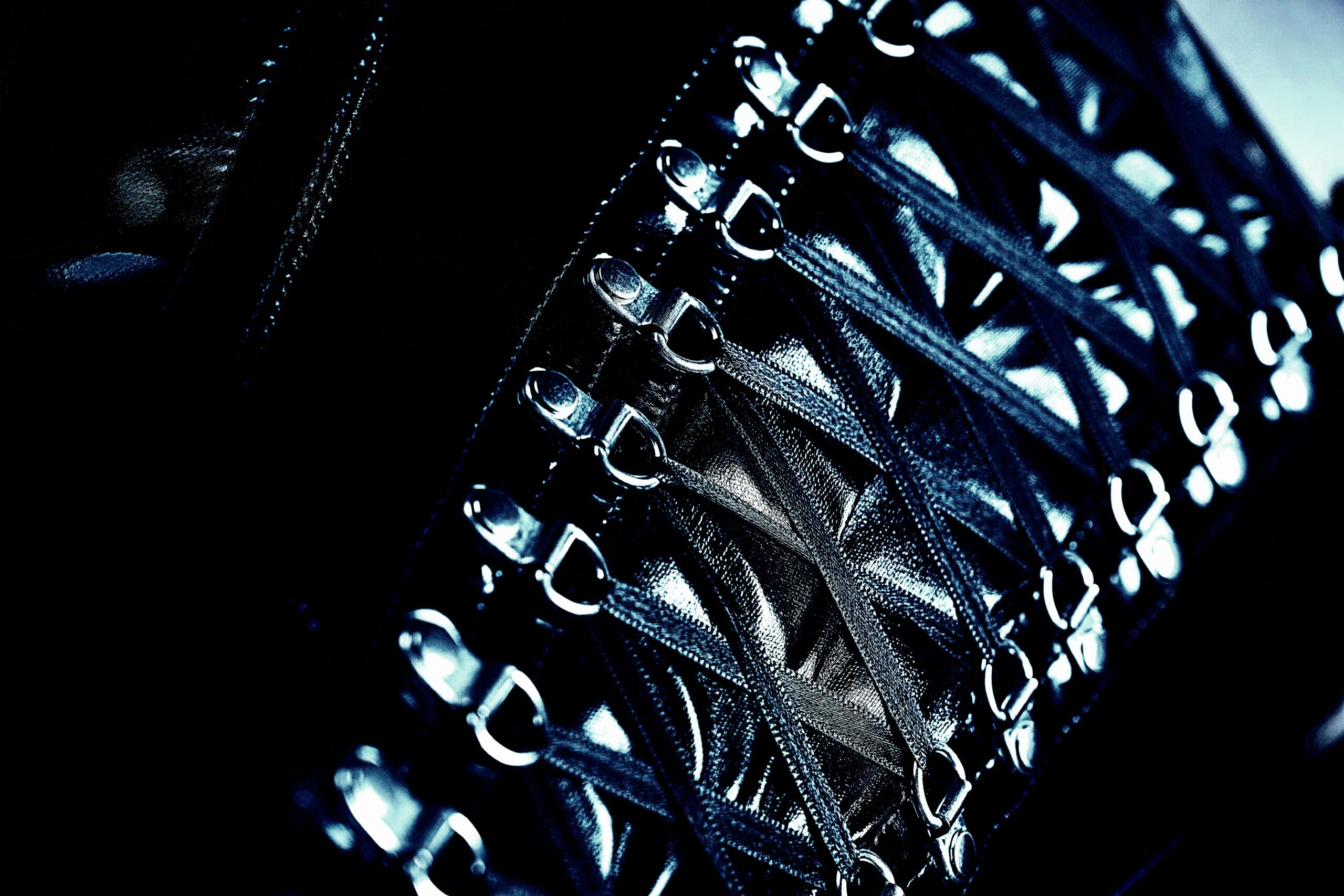 Close-up of the intricate lacing and metal hooks on a black corset, highlighting the detailed craftsmanship.