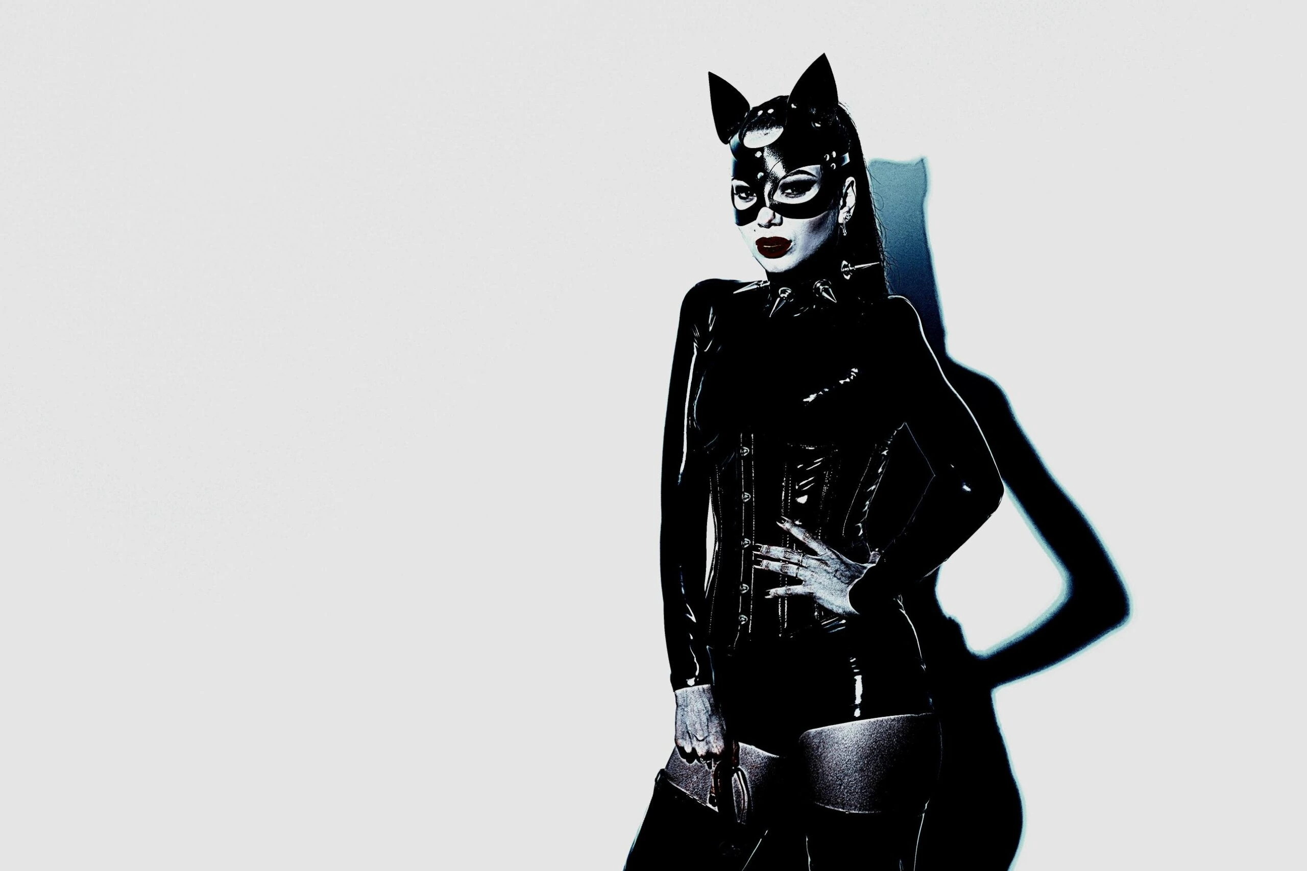 Gothic cosplay featuring a femme version of Catwoman in a sleek black latex suit and mask, embodying a bold and sensual aesthetic.