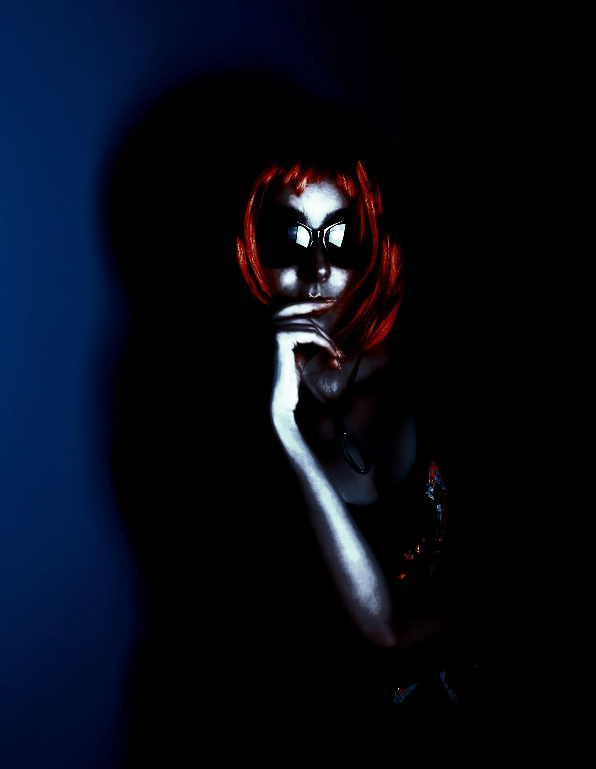 A woman with a sharp, fiery red bob, wearing black sunglasses, contemplating in the shadows with her hand resting on her chin, creating a mysterious, noir-like atmosphere.