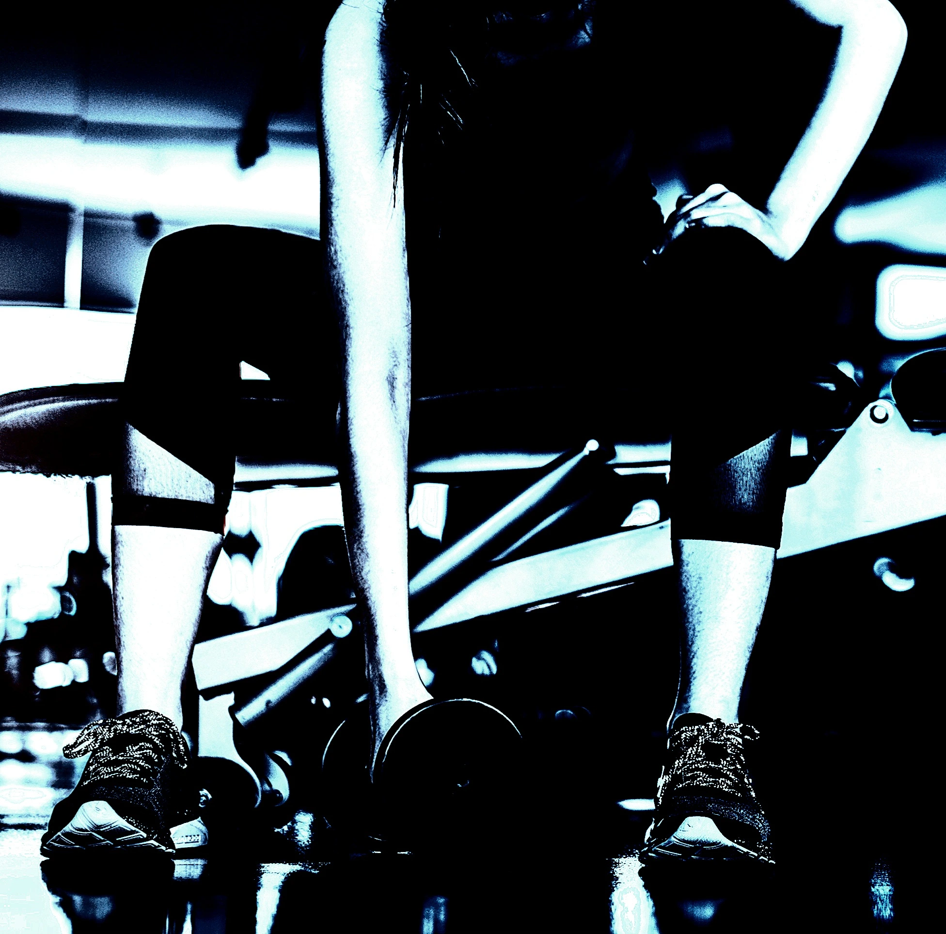 Focused woman preparing to lift a dumbbell during a workout session in a gym, with determination captured through body language.