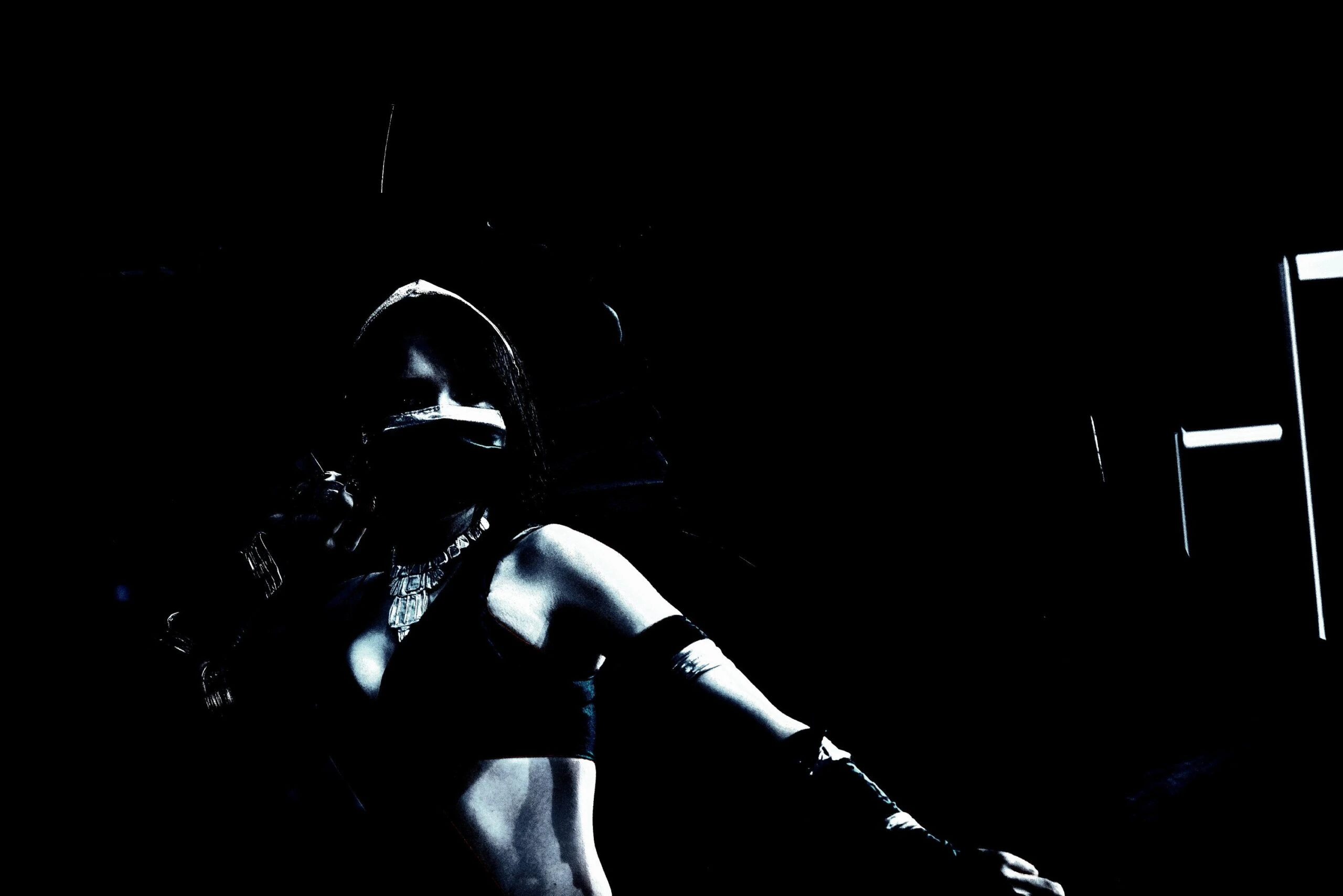 Silhouette of a cosplayer in a dark ninja-inspired costume, shrouded in shadows and exuding an intense, enigmatic vibe.