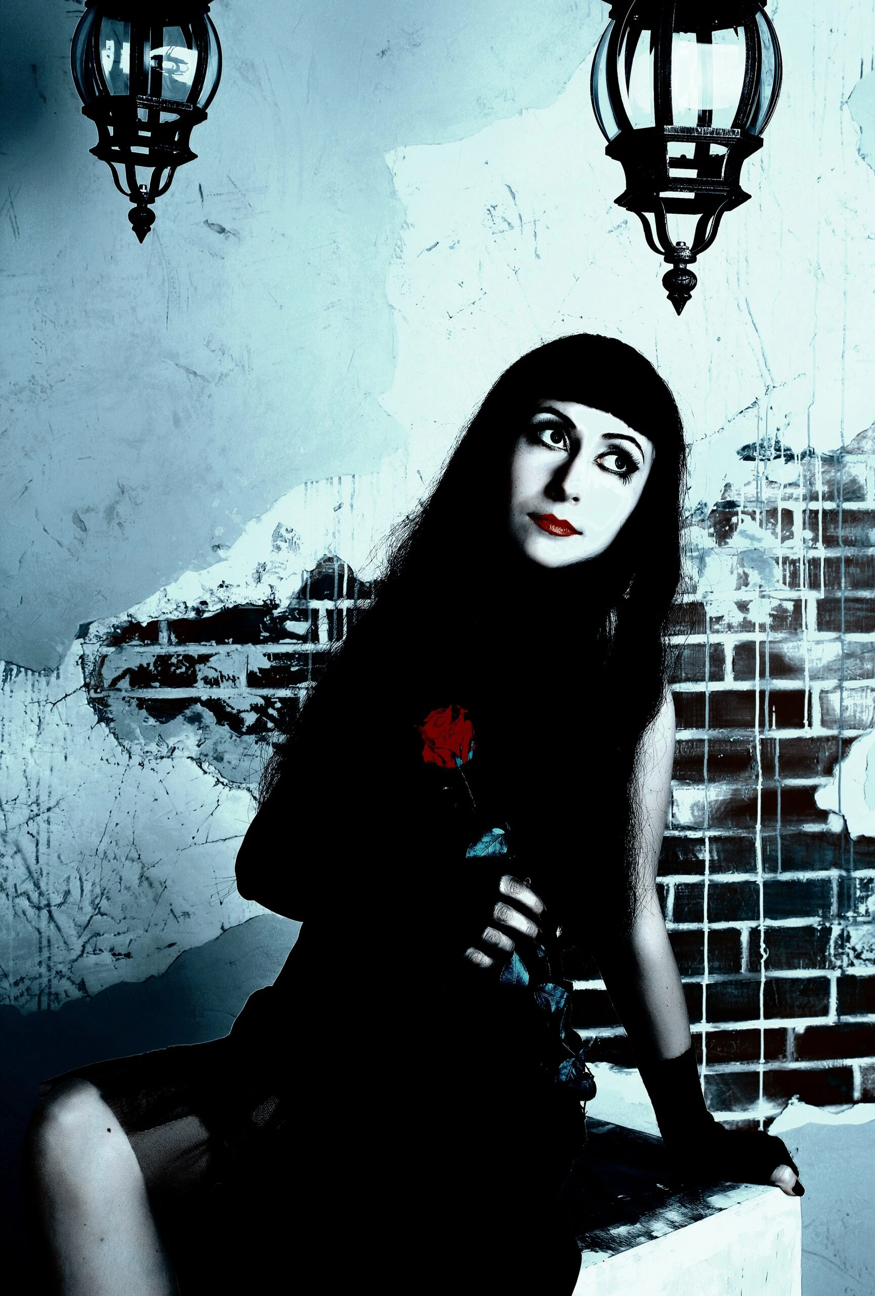 Woman in vintage gothic attire holding a red rose, sitting in front of a crumbling brick wall, with a haunting, melancholic expression.