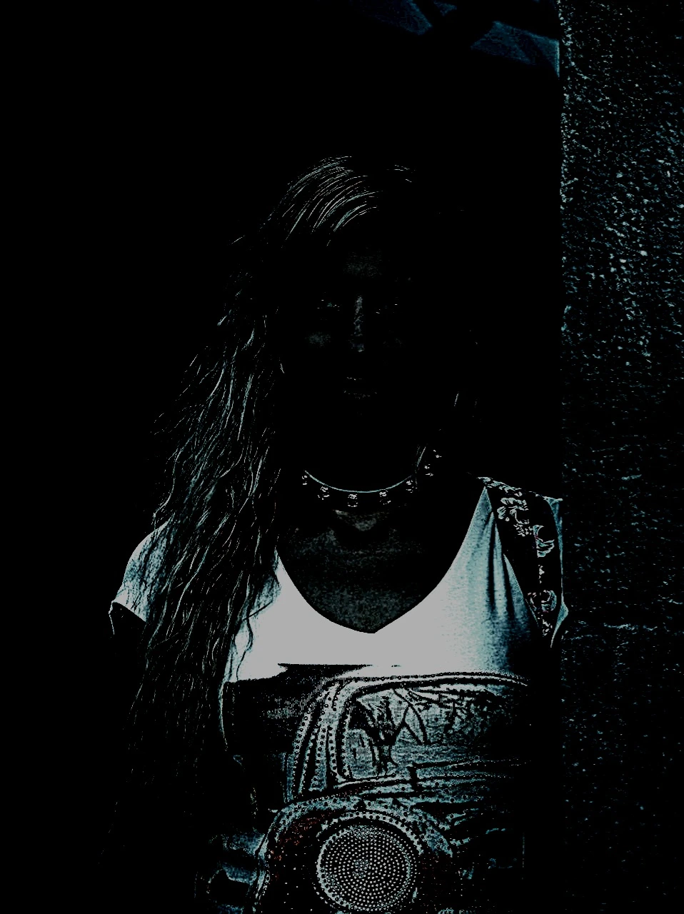 A woman posing confidently in a park setting, with her figure highlighted against the dark blue tones of the evening light. 