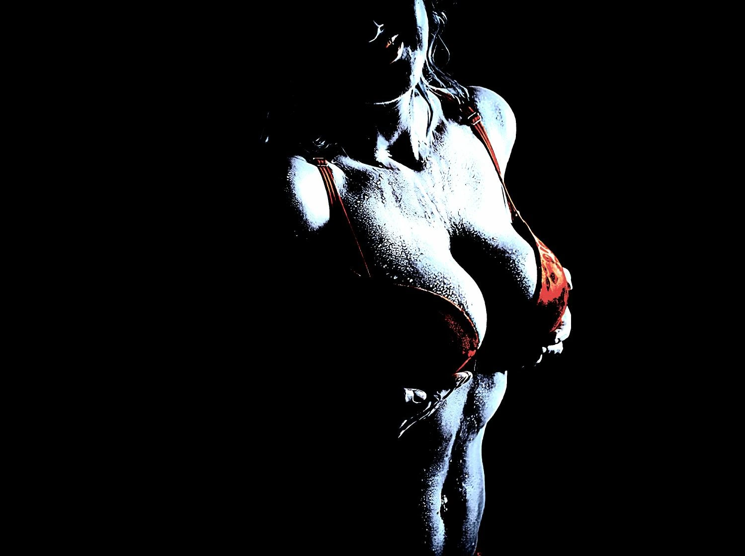 Woman in a red bra with water droplets glistening on her body, creating a powerful and sensual visual statement.