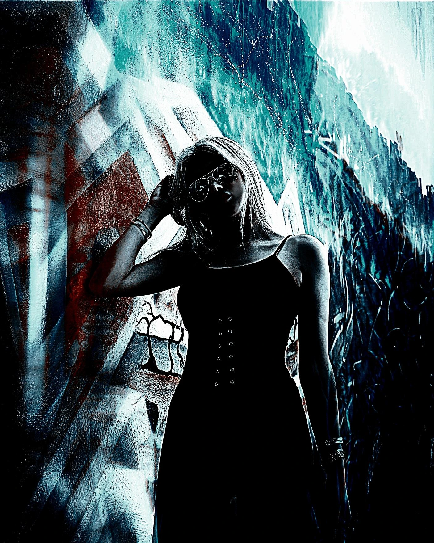 Stylish woman in a black corset dress and sunglasses posing confidently against a bold graffiti backdrop.