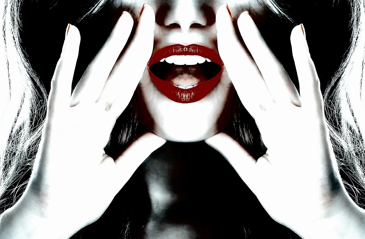 Close-up of a woman’s bright red lips and hands framing her face, creating a bold and striking look.