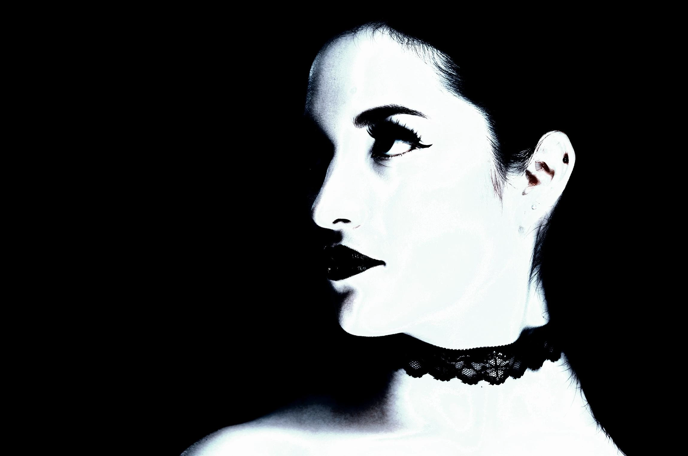 Profile of a woman wearing a black lace choker, embodying Victorian-inspired gothic elegance against a dark backdrop.
