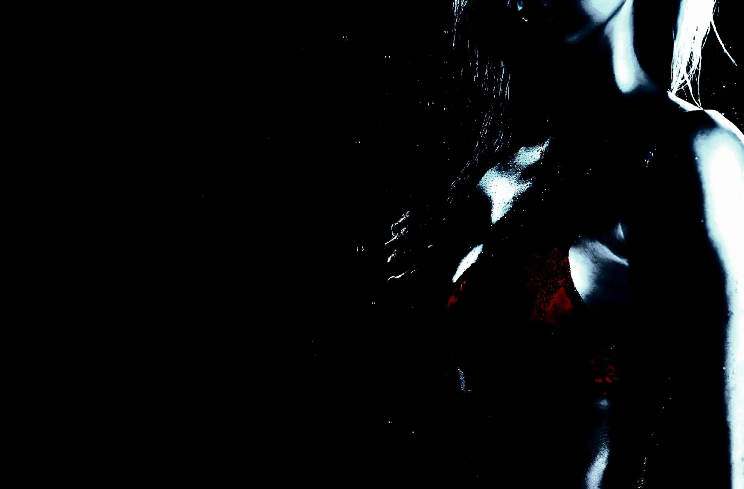Silhouette of a woman in a low-cut top, illuminated against a dark background, emphasizing curves and allure.