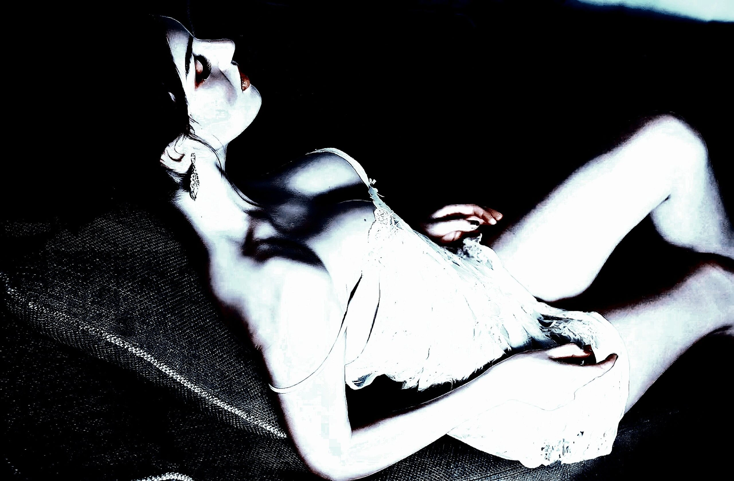 Reclining woman in a white lace dress, captured in soft lighting and a mysterious atmosphere.