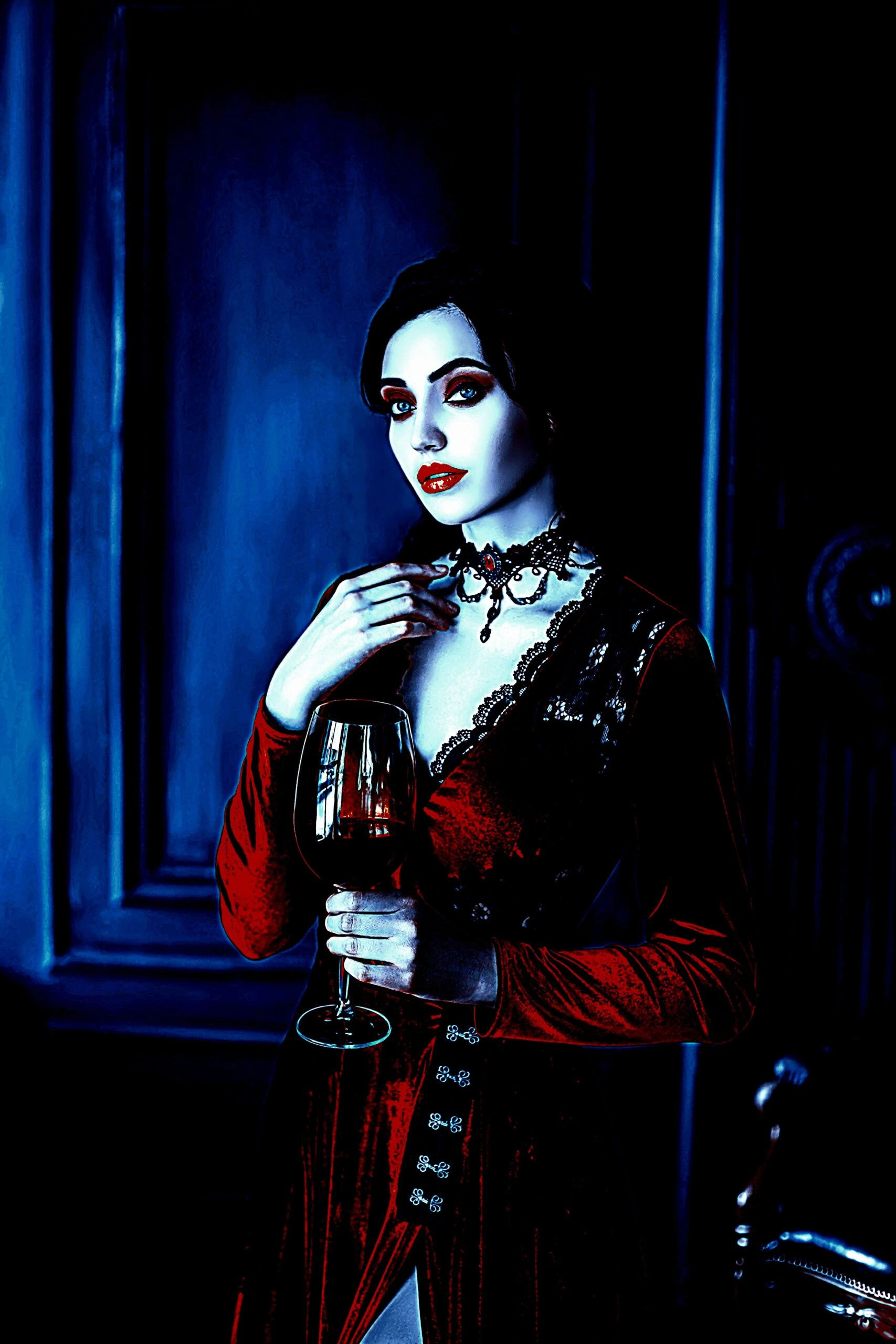 A gothic woman in a deep red velvet dress, holding a glass of wine in an elegantly moody setting.