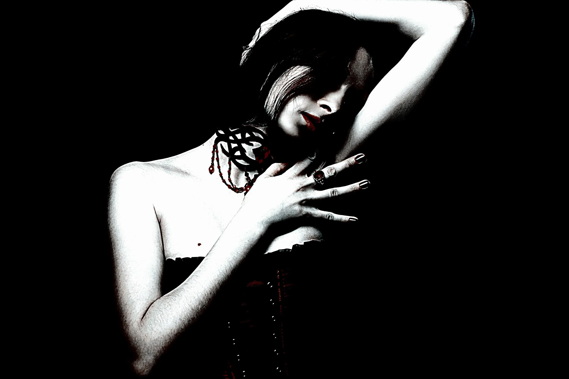 Woman in a black choker and red corset, posing gracefully with one arm raised, capturing gothic romance.