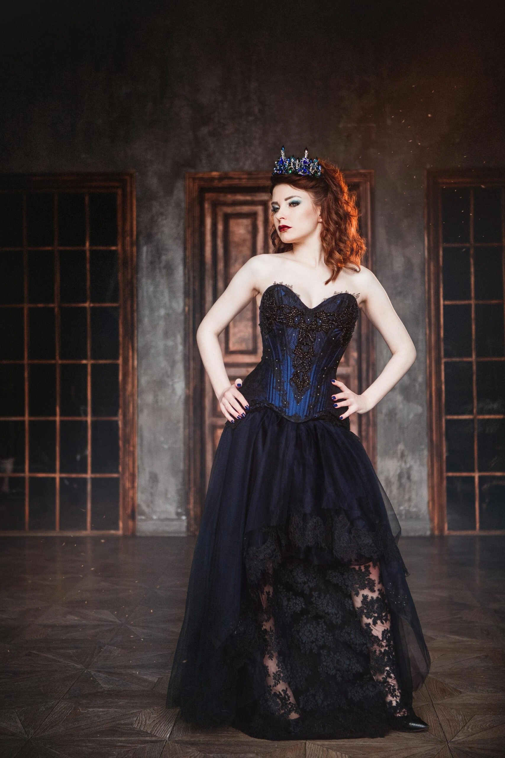 Redhead gothic queen in dark corset dress and crown, regal and defiant