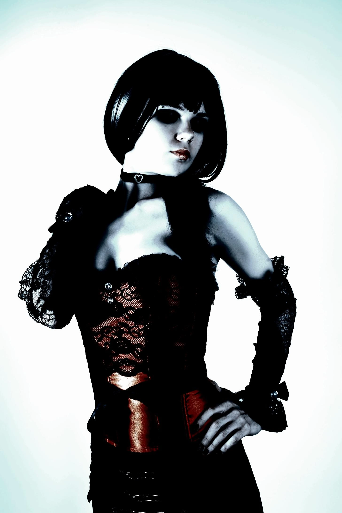 A gothic woman in a lace corset, gloves, and a choker, striking a seductive pose.