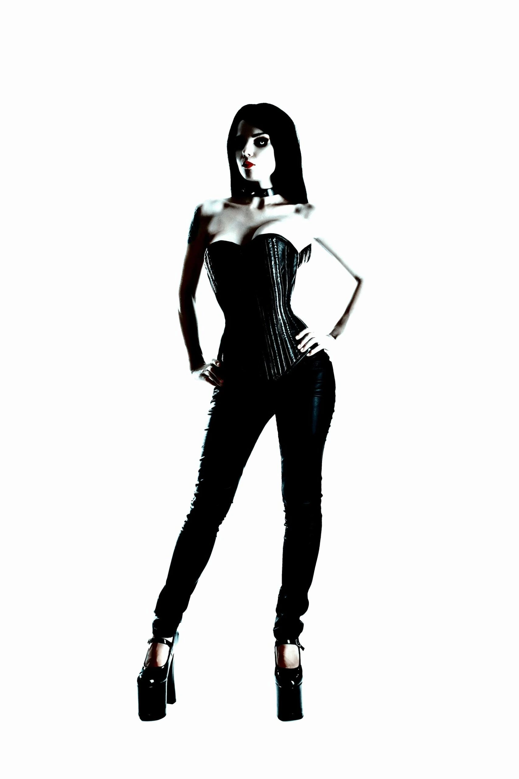 A goth model in a black corset and high heels, standing confidently against a stark white background.