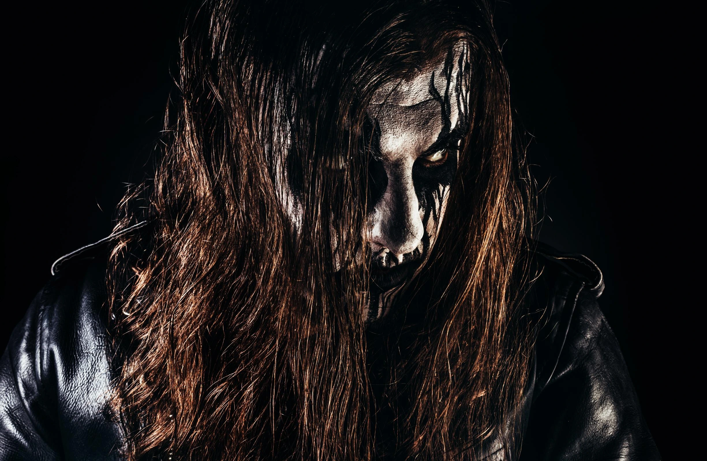 Close-up of black metal artist with corpse paint and intense glare