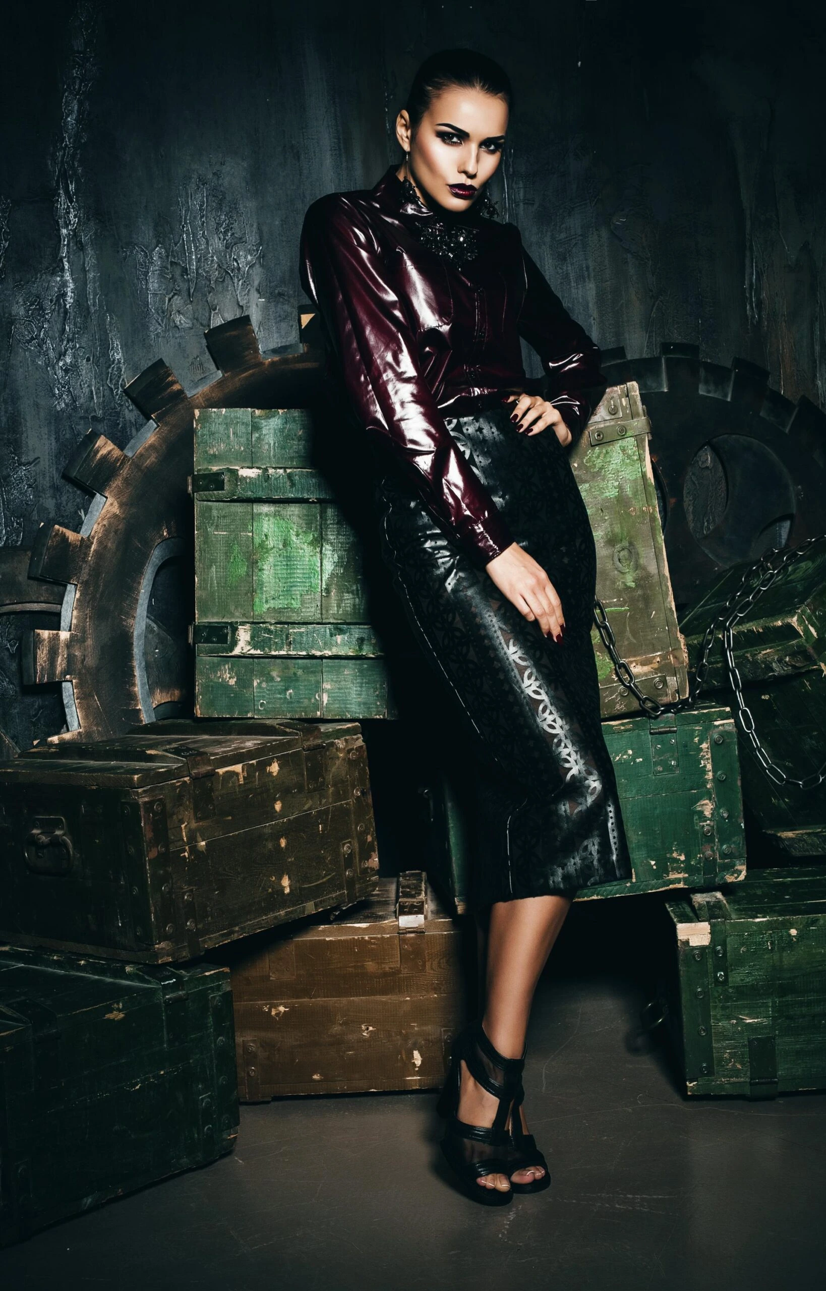 Woman pulling her ponytail in a dark latex top and high-waisted leather pencil skirt