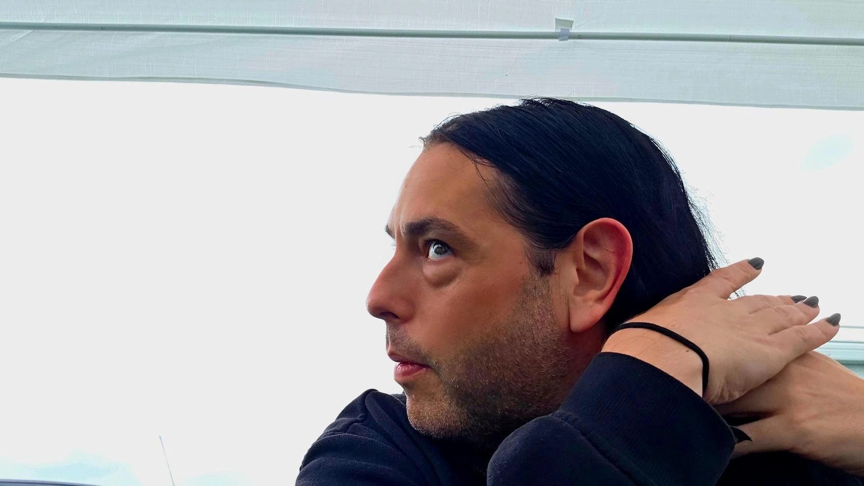Xavi at Wacken Open Air 2025, side profile adjusting hair under a festival tent