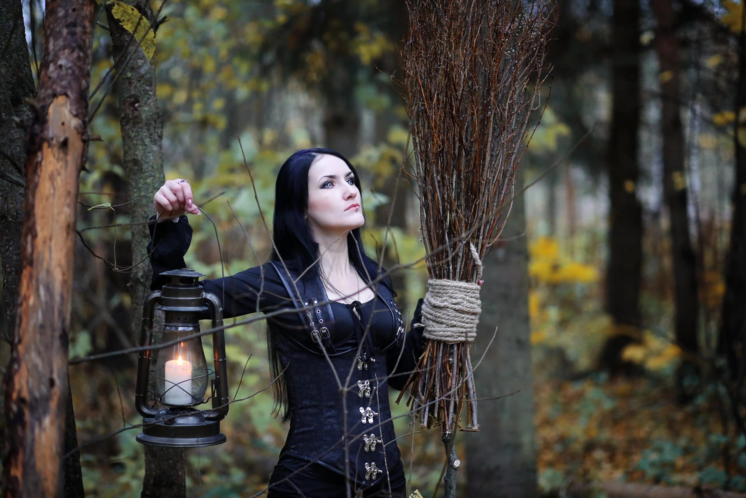Black corset with metal clasps worn outdoors, focusing on traditional corset construction and waist shaping